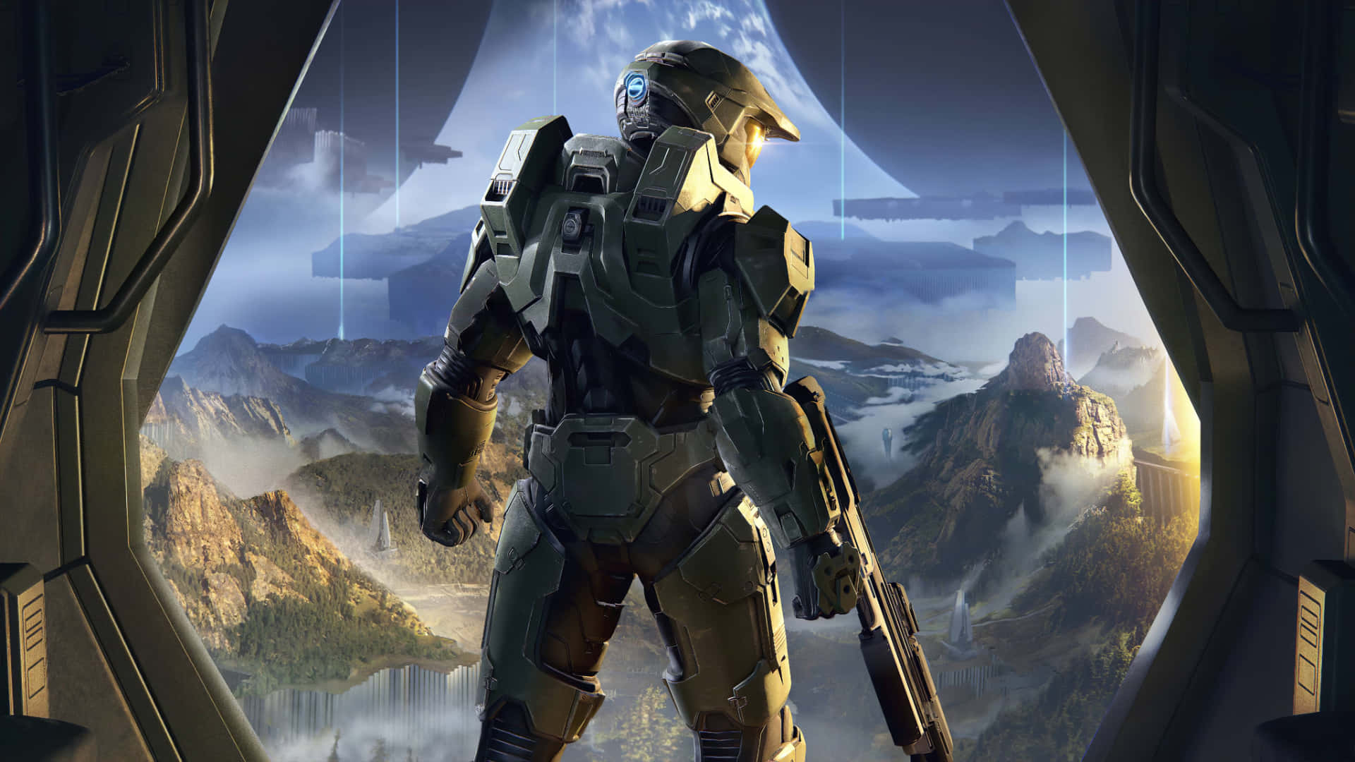 Xbox Games 桌布 壁紙 — 一名身穿綠色盔甲的斯巴達戰士站在太空船的觀景窗旁，俯瞰著發光藍天下霧氣瀰漫的外星山脈。