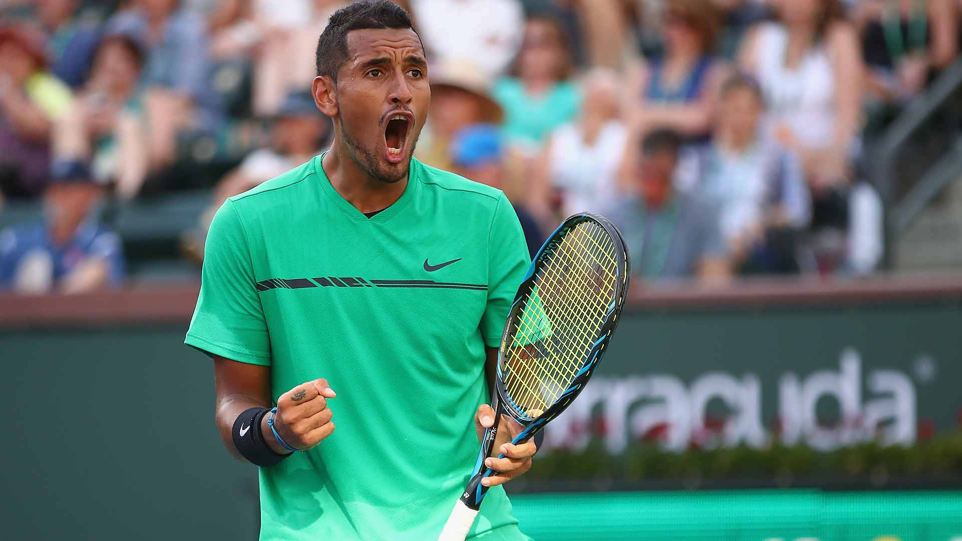 Kyrgios 桌布 壁紙 — 一名身穿綠色襯衫的男性網球選手在球場上高舉球拍勝利歡呼，身後有模糊的觀眾。