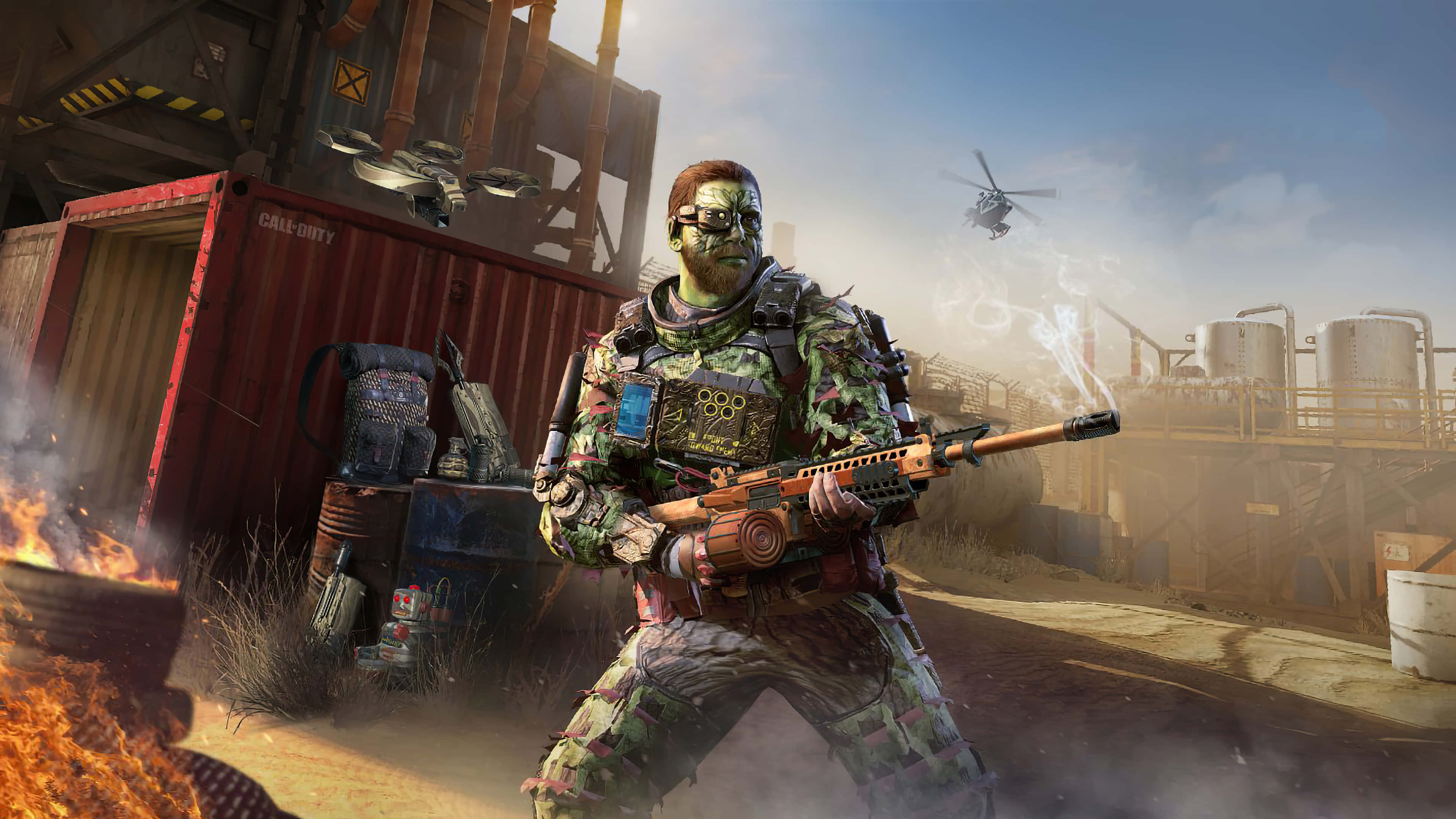 Call Of Duty 2020 桌布 壁紙 — 一名身穿綠色迷彩裝備的士兵，在煙霧瀰漫的天空下，於燃燒的油桶和工業貨櫃之間發射冒煙的步槍。