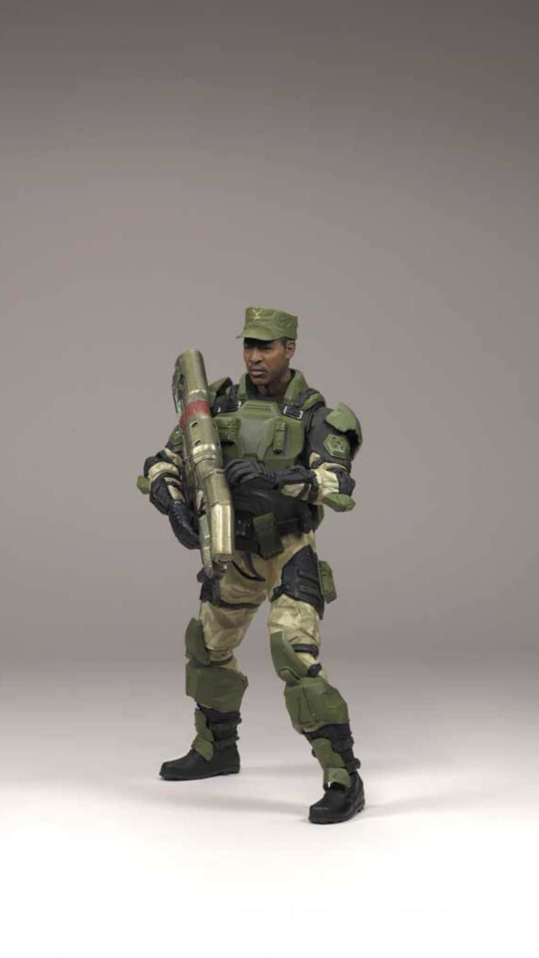 Sergeant Johnson 桌布 壁紙 — 一名身穿綠色迷彩裝備的士兵在純灰色攝影棚背景前手持大型火箭發射器。