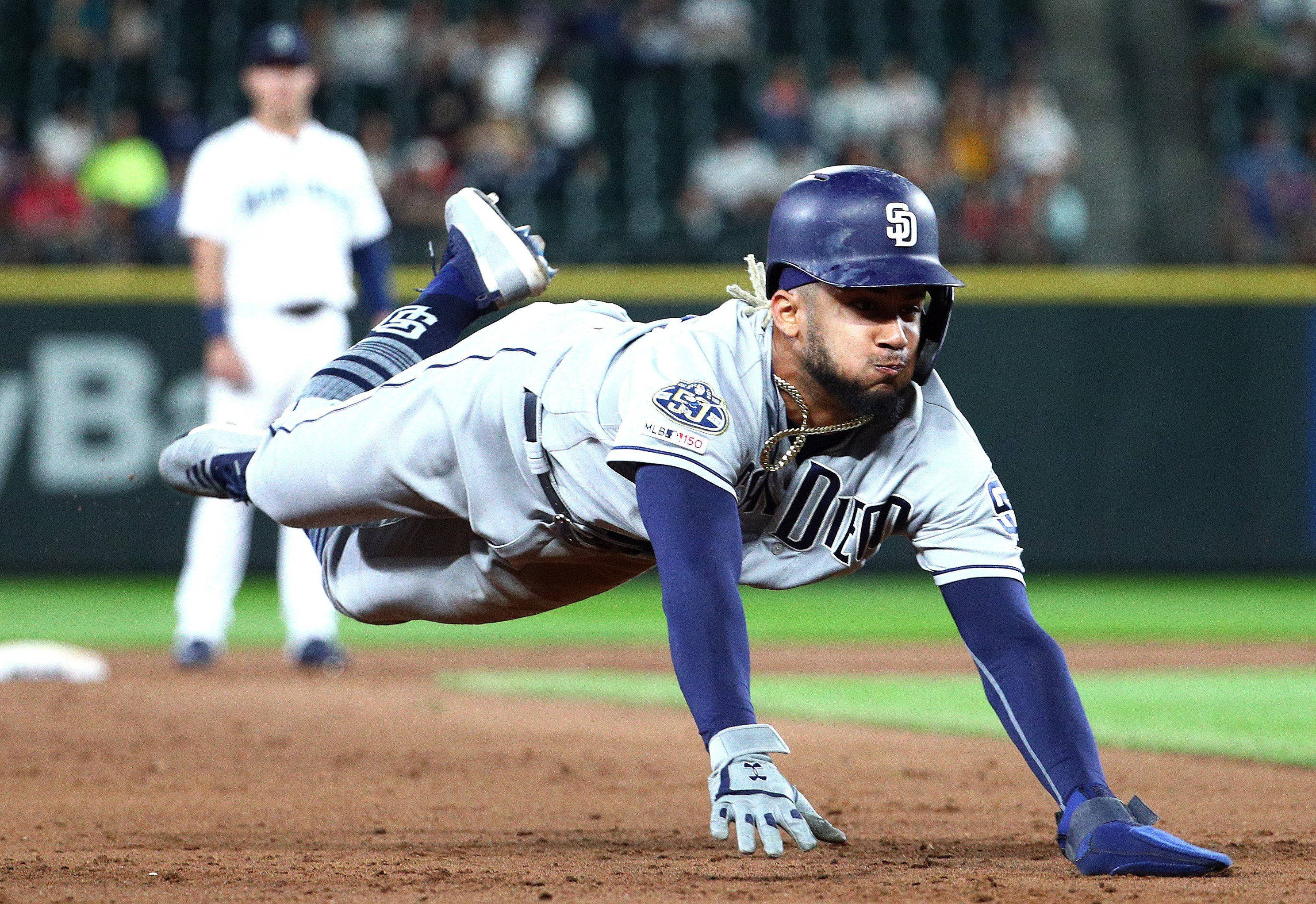 Tatis 桌布 壁紙 — 一名身穿聖地牙哥教士隊球衣的棒球選手在夜間比賽中，在球場燈光下以頭部滑壘方式進壘。