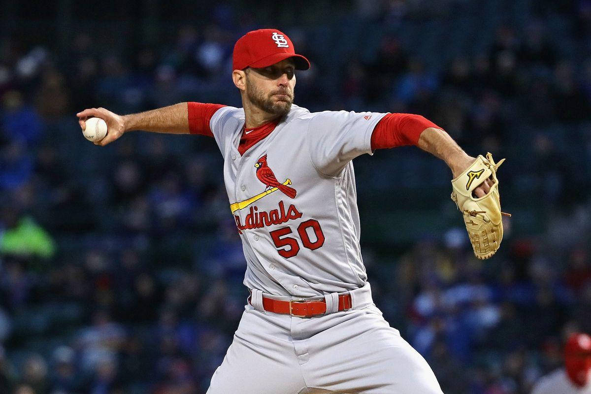 Adam Wainwright 桌布 壁紙 — 一名身穿聖路易紅雀隊球衣的棒球投手在球場燈光下投球，背景有模糊的球迷。