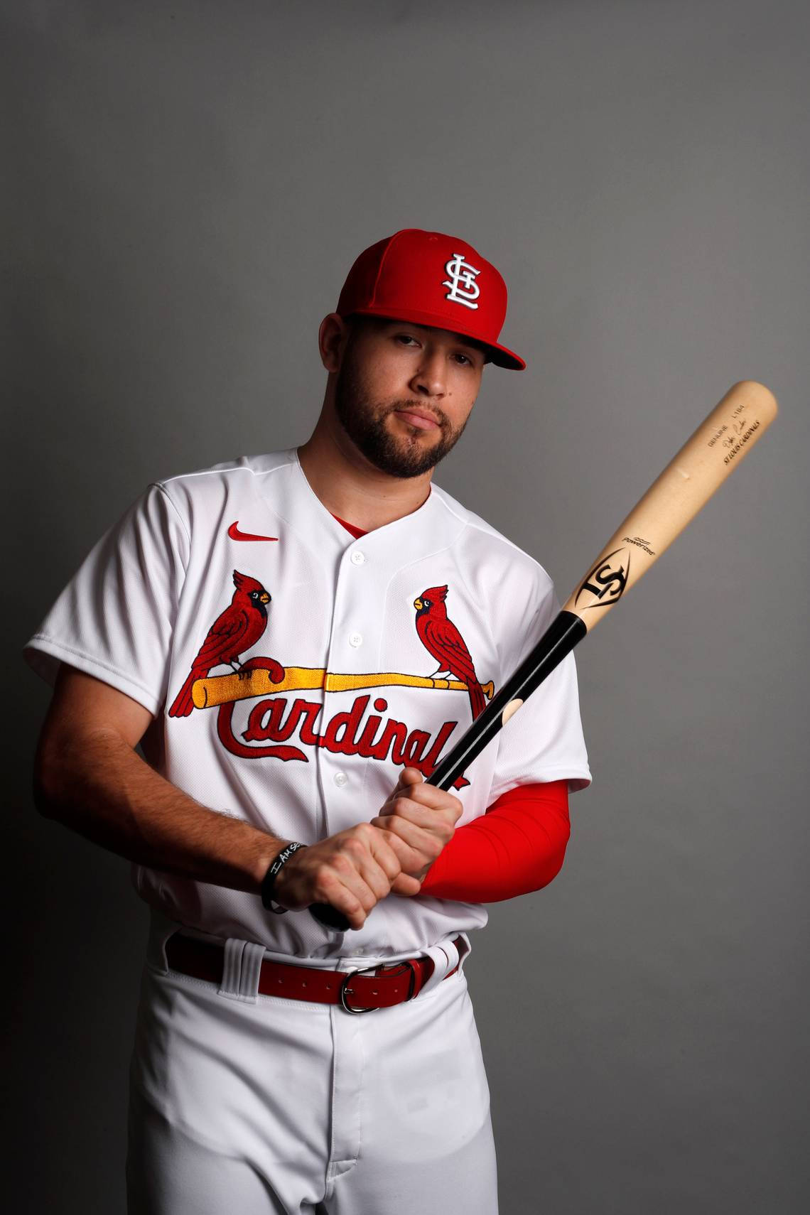 Cardinals 桌布 壁紙 — 一名身穿聖路易紅雀隊球衣的棒球運動員在純灰色攝影棚背景前手持球棒。