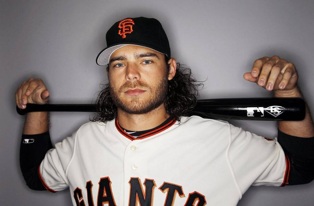 San Francisco Giants 桌布 壁紙 — 一名身穿舊金山巨人隊球衣的棒球選手，在純灰色背景前將球棒扛在肩上。