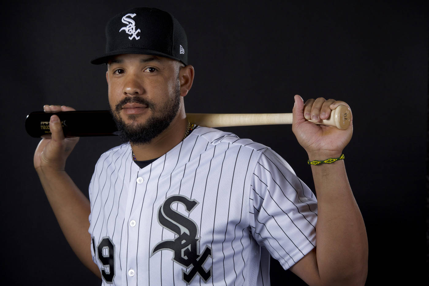 jose abreu 桌布 壁紙 — 一名身穿芝加哥白襪隊球衣的棒球選手，在深色背景前將球棒扛在肩上。
