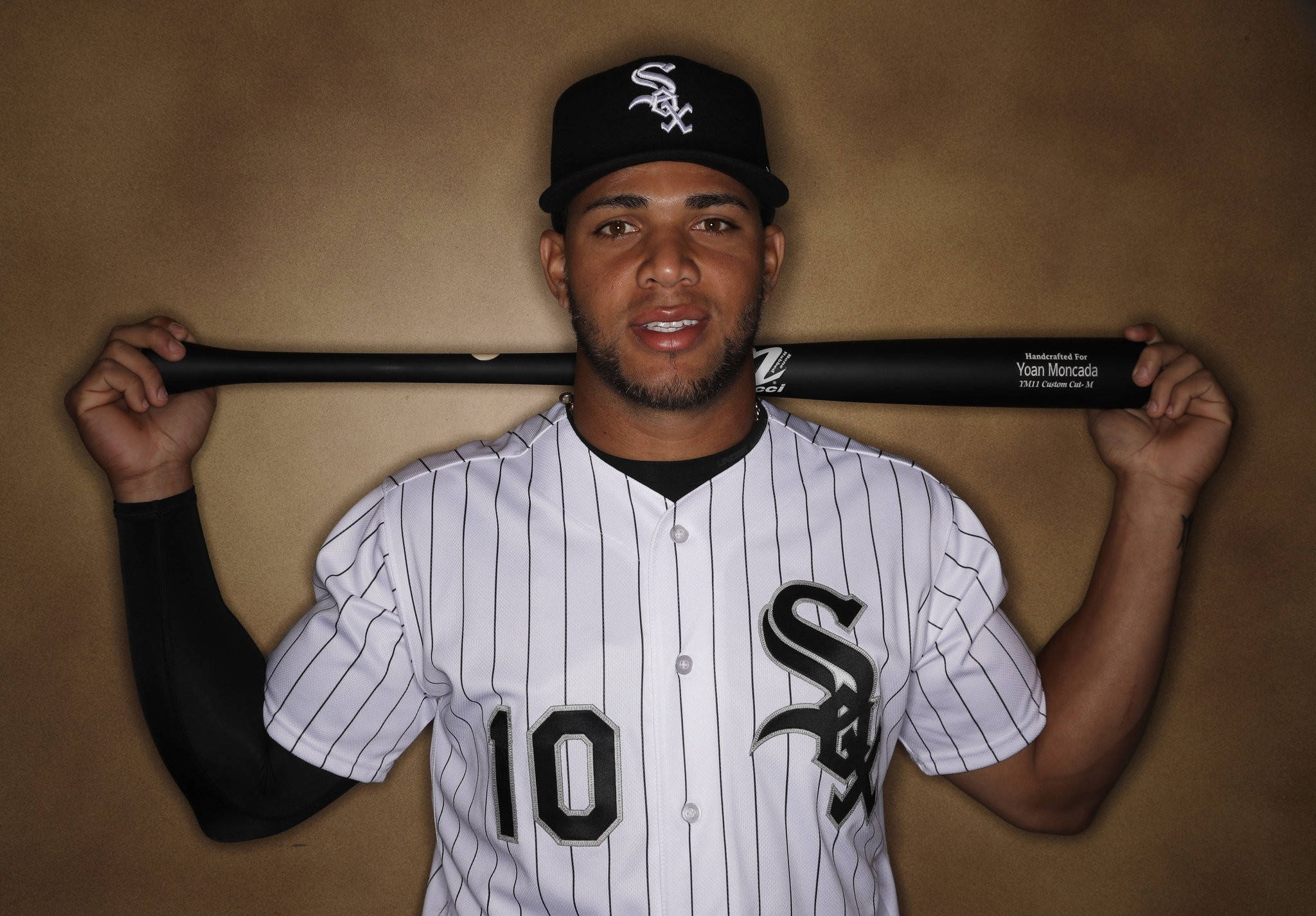 MLB Players 桌布 壁紙 — 一名身穿芝加哥白襪隊球衣的棒球選手，在純棕色背景前將球棒扛在肩上。