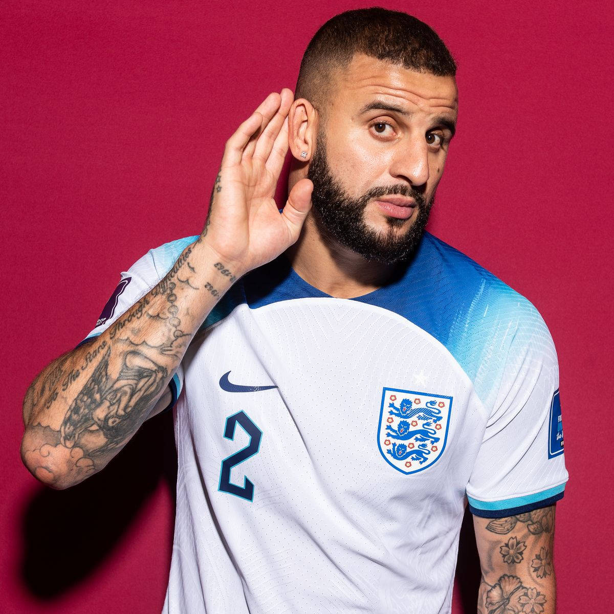 Kyle Walker 桌布 壁紙 — 一名身穿英格蘭球衣、手臂上有刺青的足球員在充滿活力的洋紅色背景前擺姿勢。