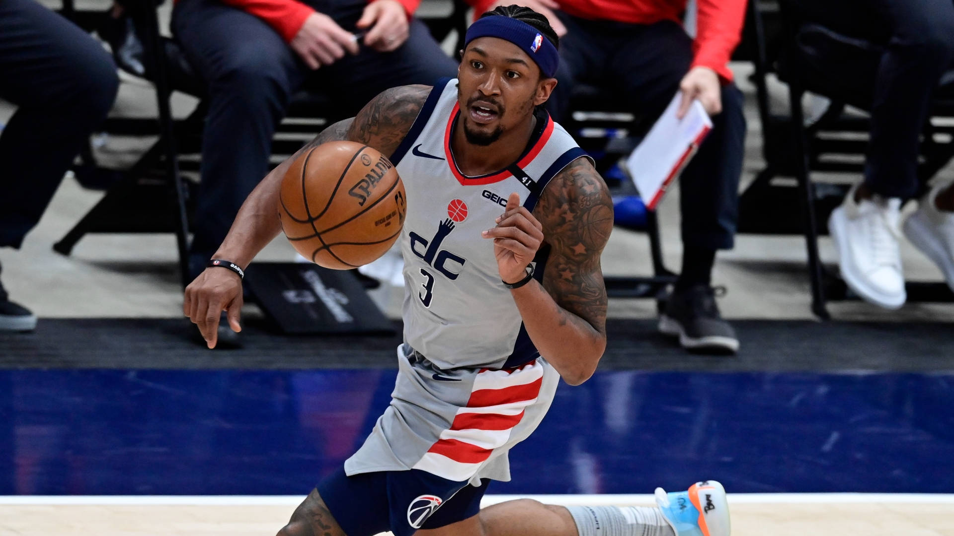 Bradley Beal 桌布 壁紙 — 一名身穿華盛頓巫師隊球衣的籃球運動員在比賽中專注地運球，充滿決心。