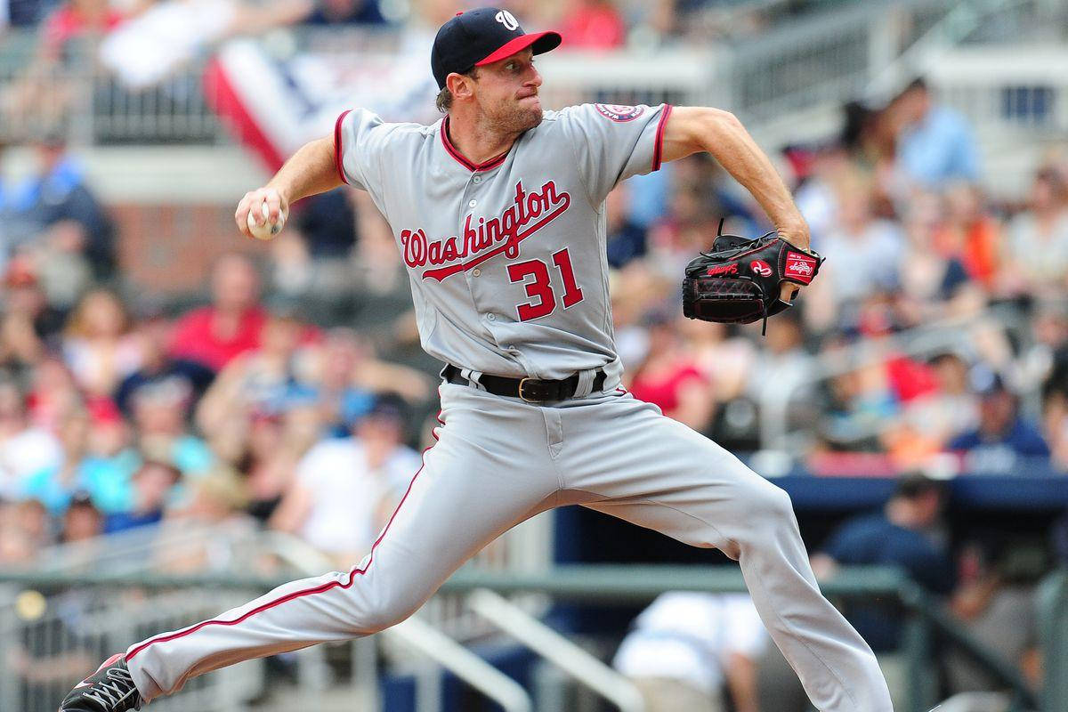 Max Scherzer 桌布 壁紙 — 一名身穿華盛頓球衣的棒球投手在陽光普照的日子中投球，背景有模糊的球迷。