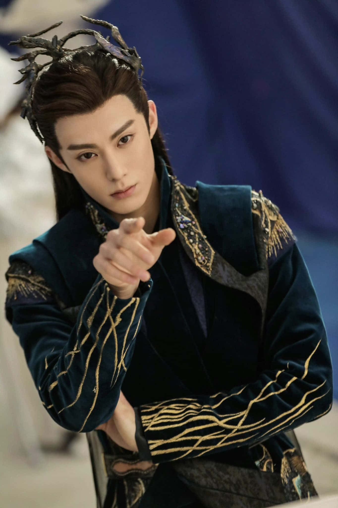 Dylan Wang 桌布 壁紙 — 一名身穿華麗深藍色和金色服飾、頭戴鹿角狀頭飾的男子，以強烈的目光直指觀眾。