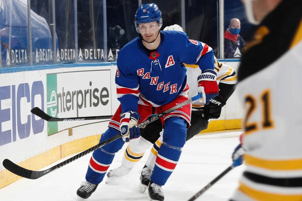 hockey 桌布 壁紙 — 一名身穿藍、紅、白色球衣的紐約遊騎兵冰球球員在比賽中於冰上激烈滑行，附近有對手。