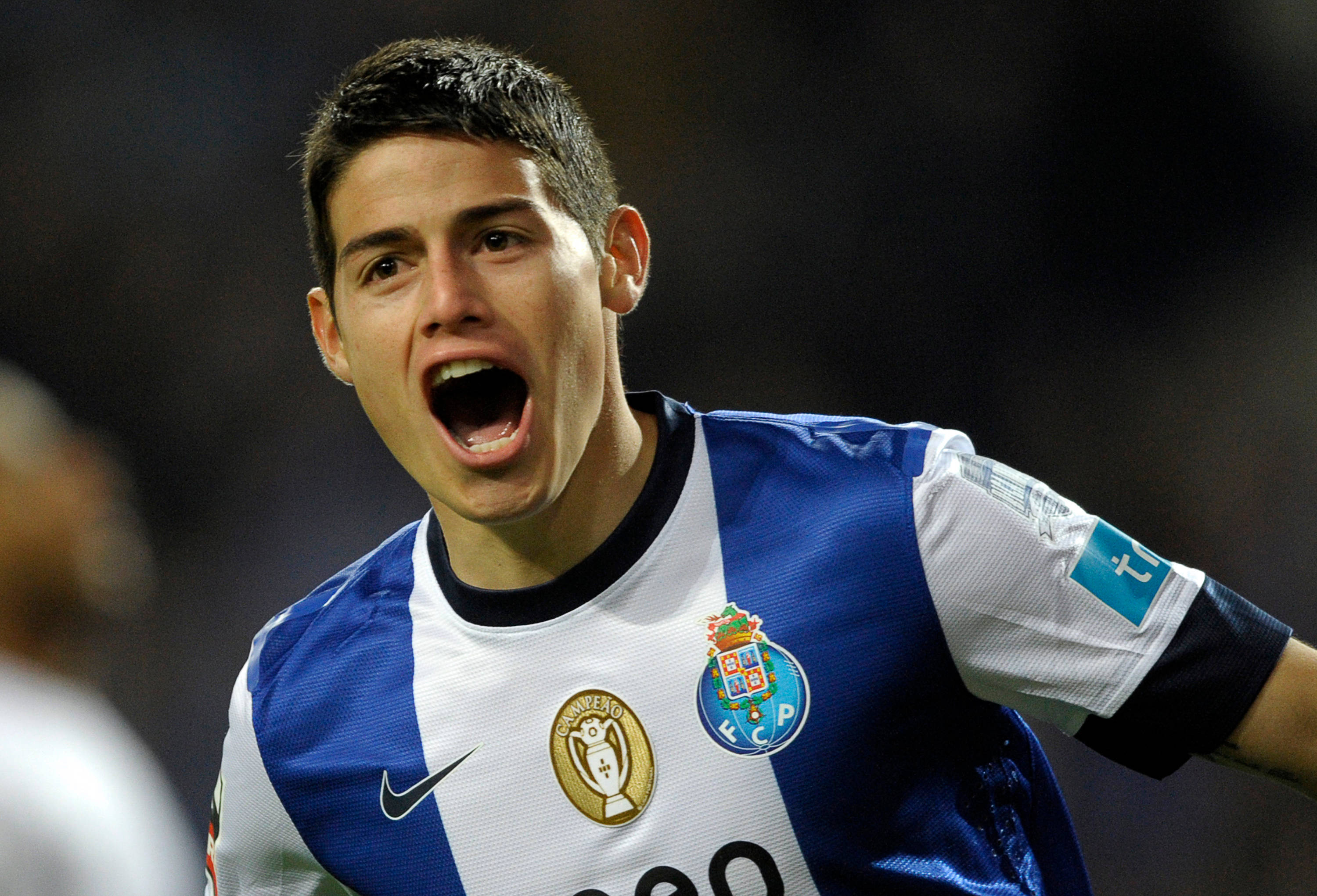 James Rodriguez 桌布 壁紙 — 一名身穿藍白條紋球衣的足球員在球場燈光下張開嘴巴，以強烈的表情慶祝。