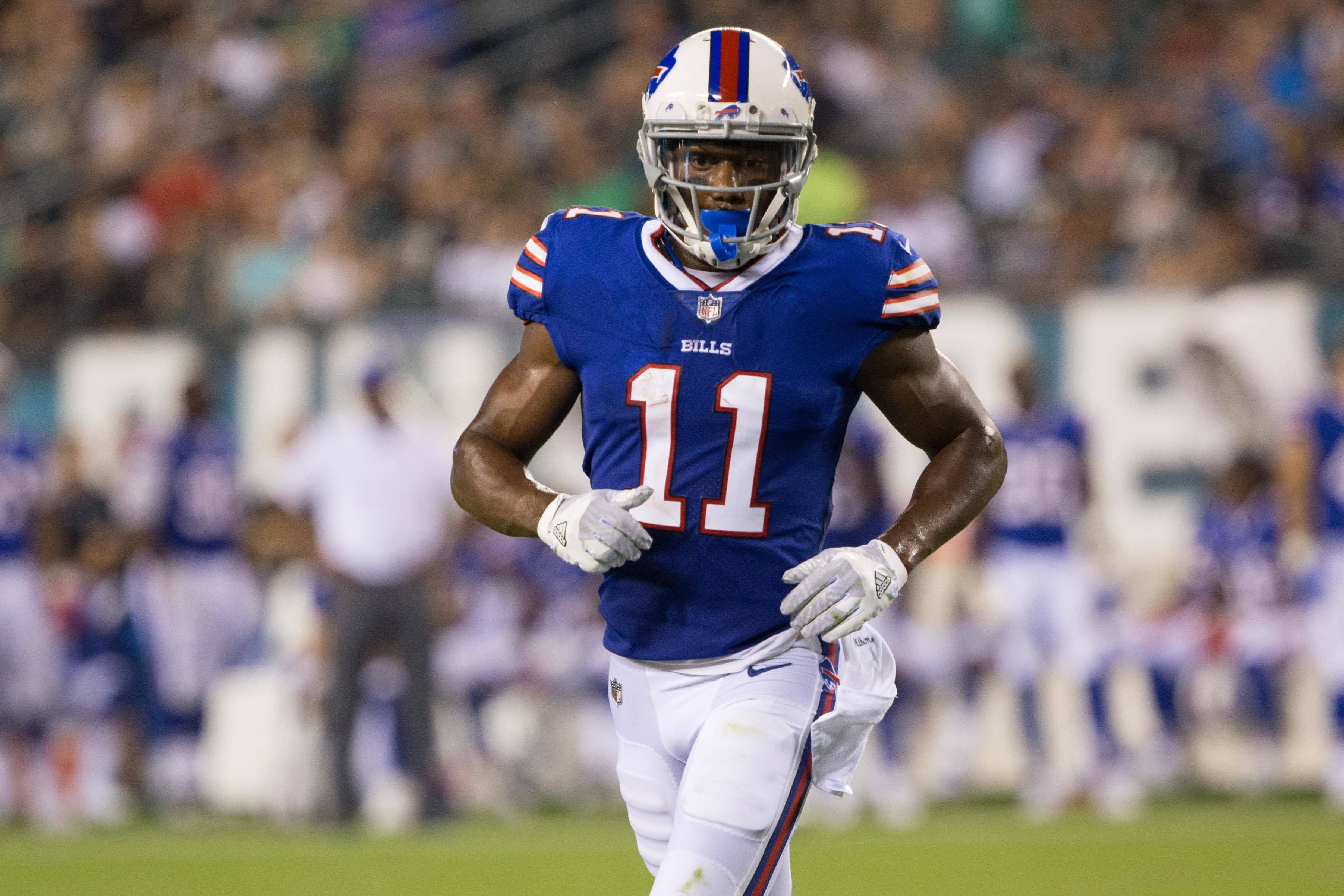 zay jones 桌布 壁紙 — 一名身穿藍白球衣的水牛城比爾隊美式足球員在夜間比賽中於球場燈光下衝刺。