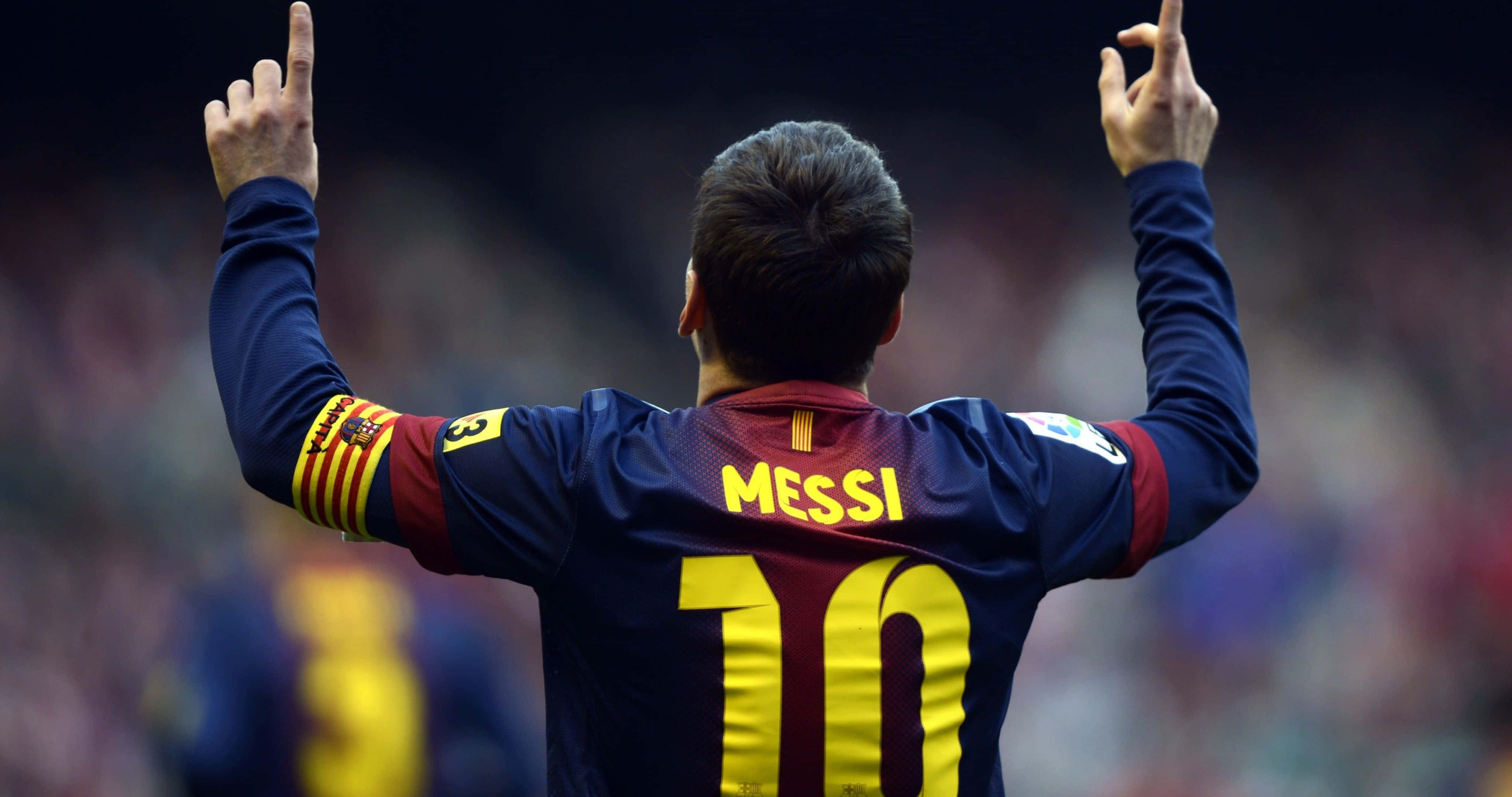 Sports 4K 桌布 壁紙 — 一名身穿藍紅球衣、背後印有「MESSI」和10號的足球員高舉雙手慶祝，手指指向天空。