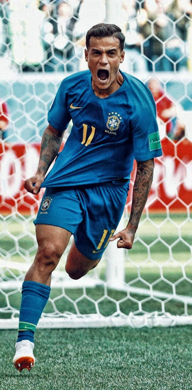 Coutinho 桌布 壁紙 — 一名身穿藍色11號球衣的巴西足球員在球門網附近張開嘴巴、握緊拳頭瘋狂慶祝。