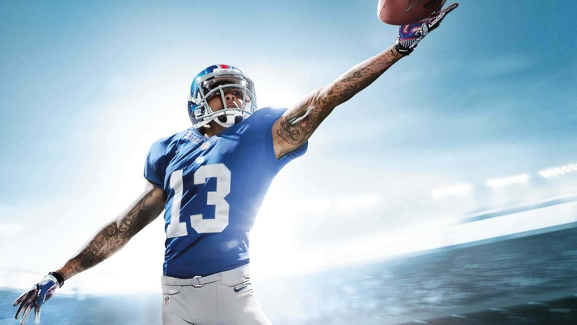 Obj 桌布 壁紙 — 一名身穿藍色13號球衣的足球運動員在明亮的天空下凌空接球。