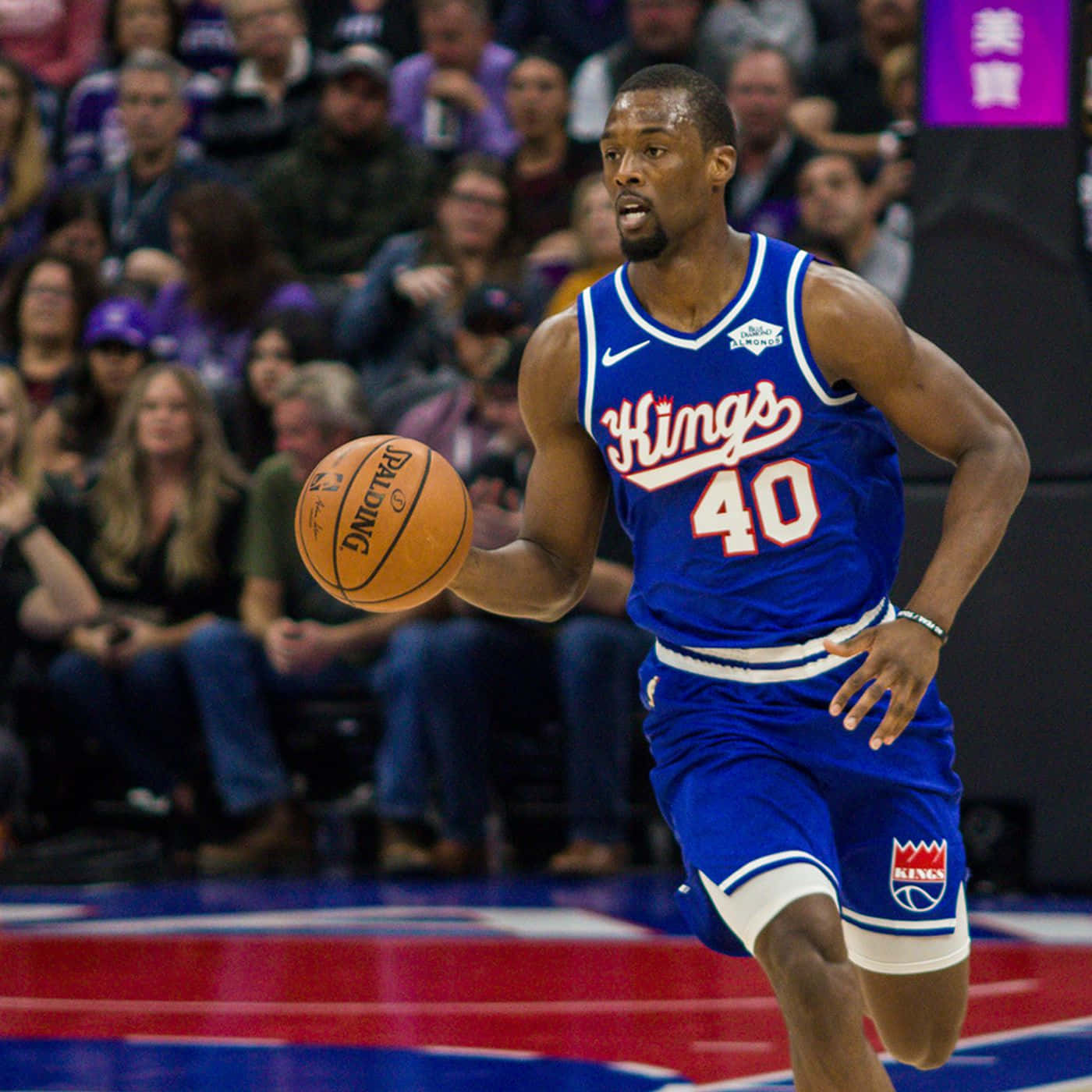 NBA 桌布 壁紙 — 一名身穿藍色Kings球衣的籃球運動員在比賽中激烈運球，背景是模糊的人群。