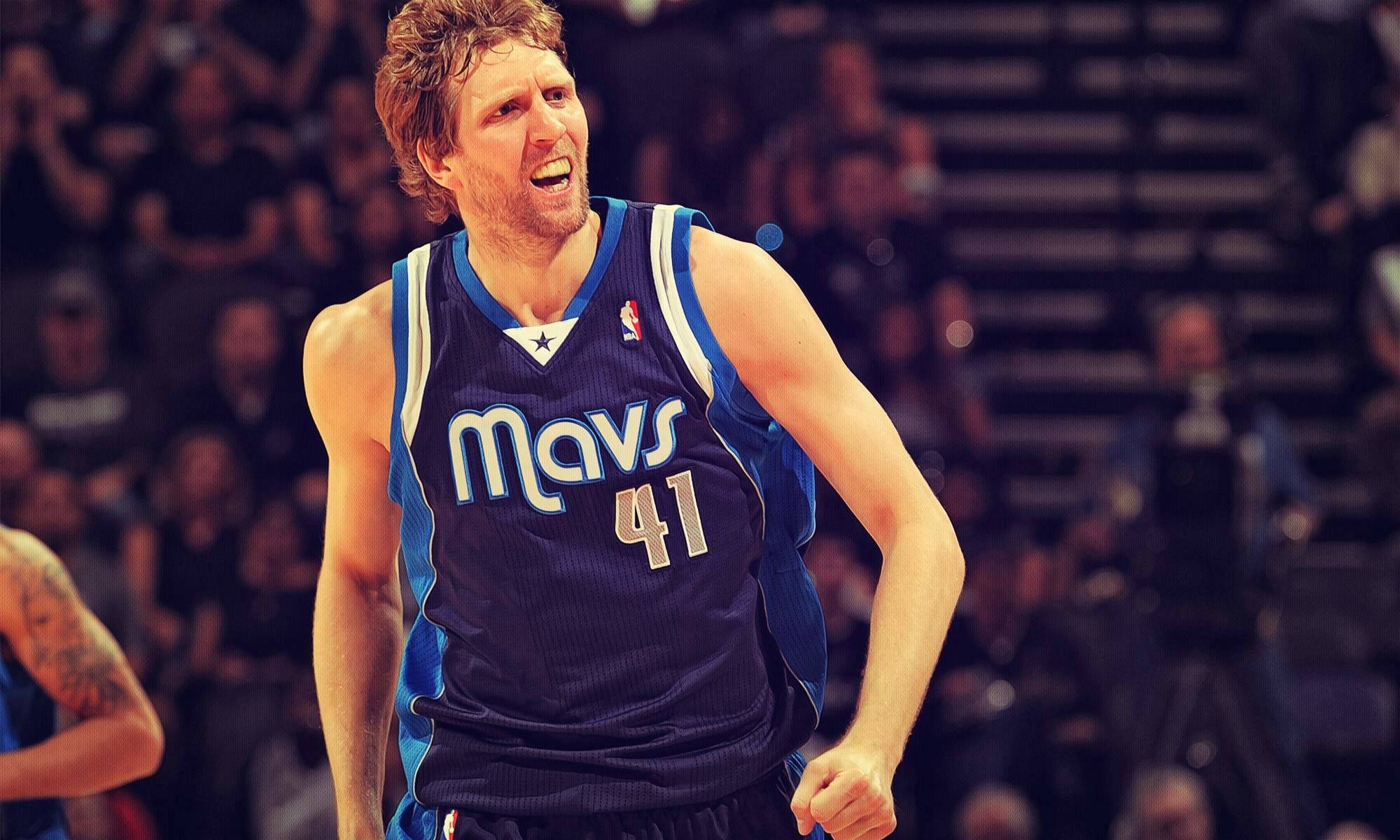 Dirk Nowitzki 桌布 壁紙 — 一名身穿藍色Mavs球衣41號的籃球運動員在場館燈光下比賽時激烈咆哮。