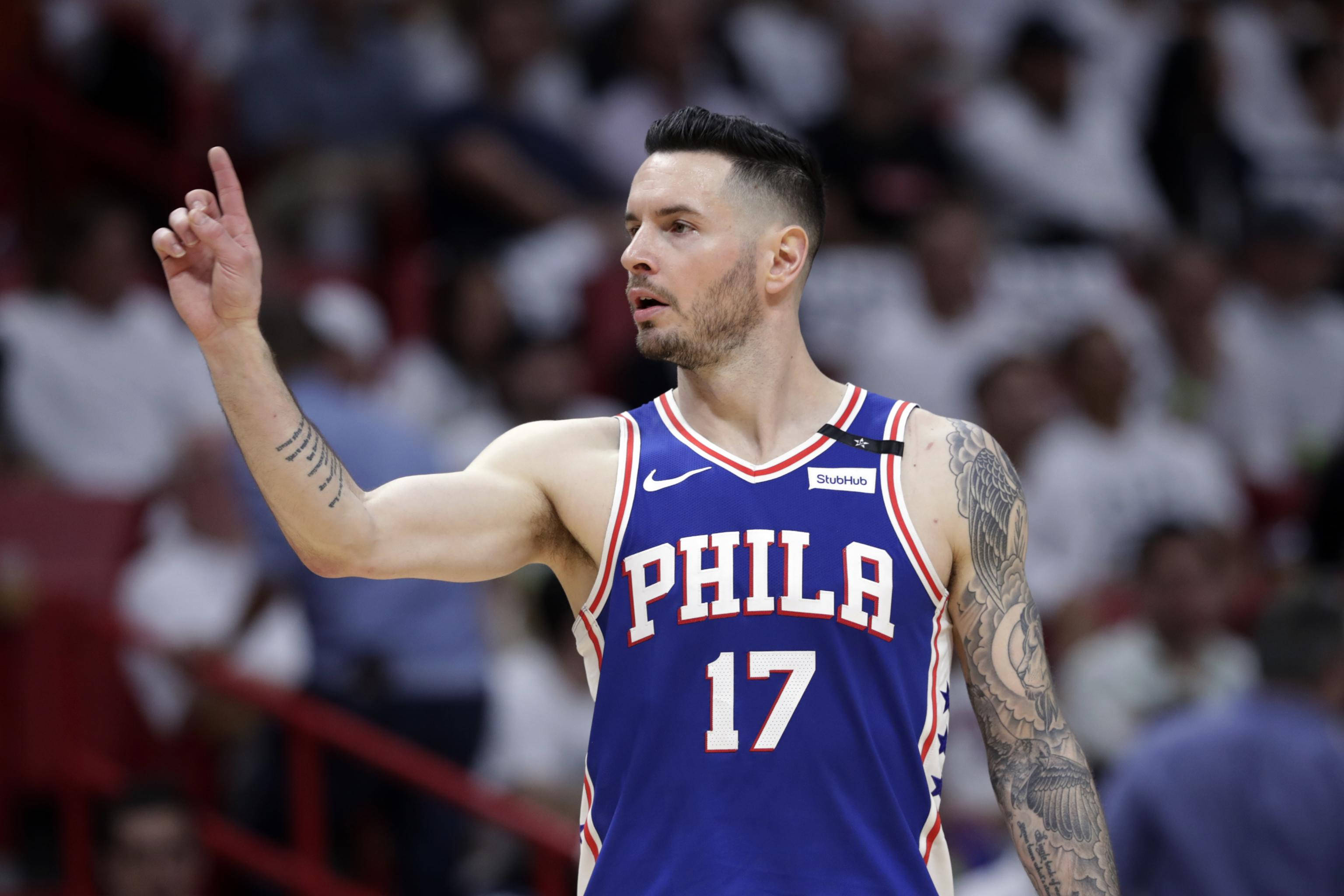 Jj Redick 桌布 壁紙 — 一名身穿藍色Phila球衣、號碼17的籃球運動員在比賽中向上做手勢，背景是模糊的觀眾。