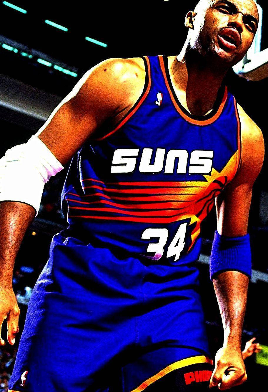 NBA 桌布 壁紙 — 一名身穿藍色Suns球衣、背號34的籃球運動員在明亮的場館燈光下，於比賽中專注地凝視。
