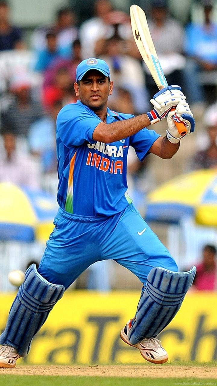 MS Dhoni 桌布 壁紙 — 一名身穿藍色印度隊服的板球手在日間比賽中揮動球棒，球正接近中。