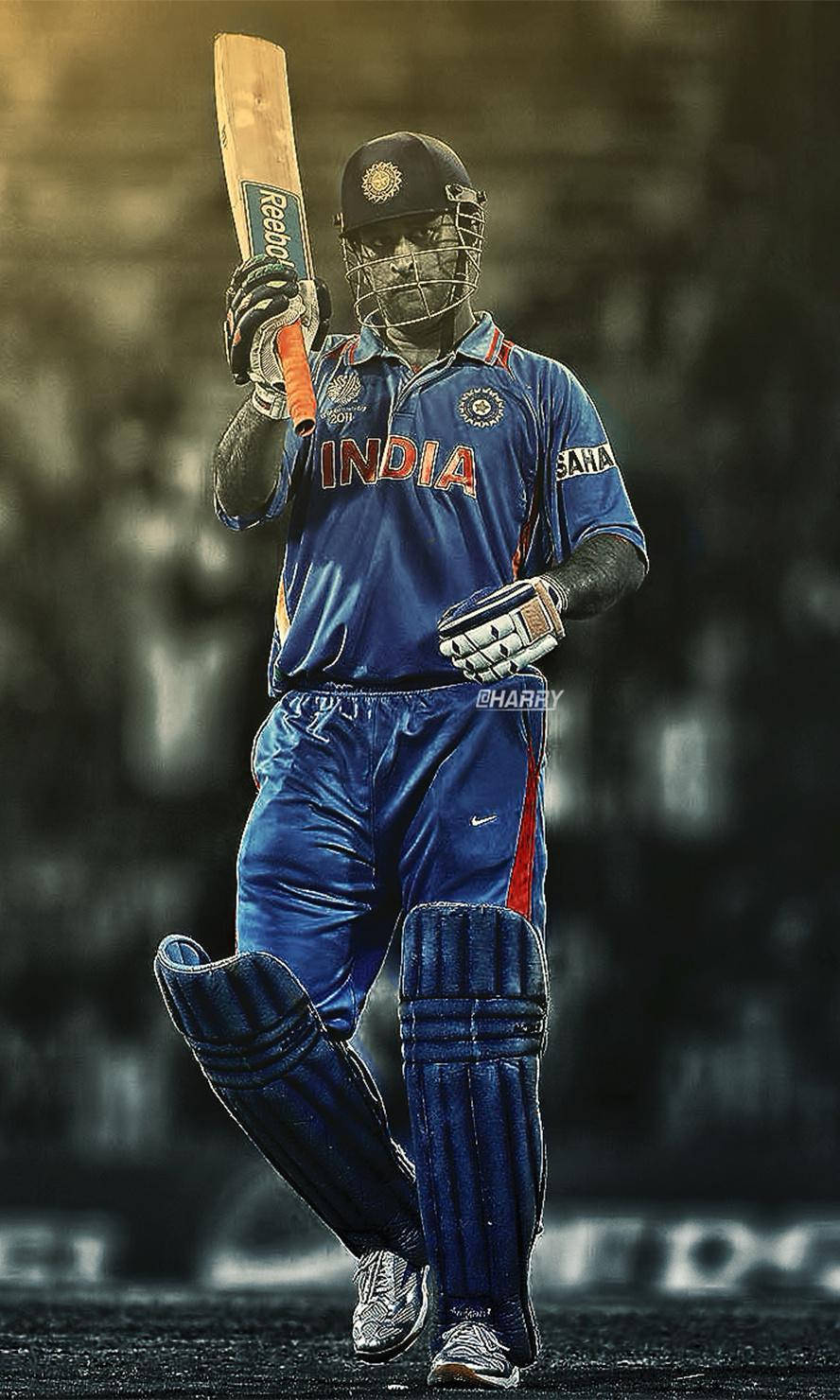 MS Dhoni 桌布 壁紙 — 一名身穿藍色印度隊服的板球運動員在球場上，在體育場燈光下以勝利姿態高舉球棒。