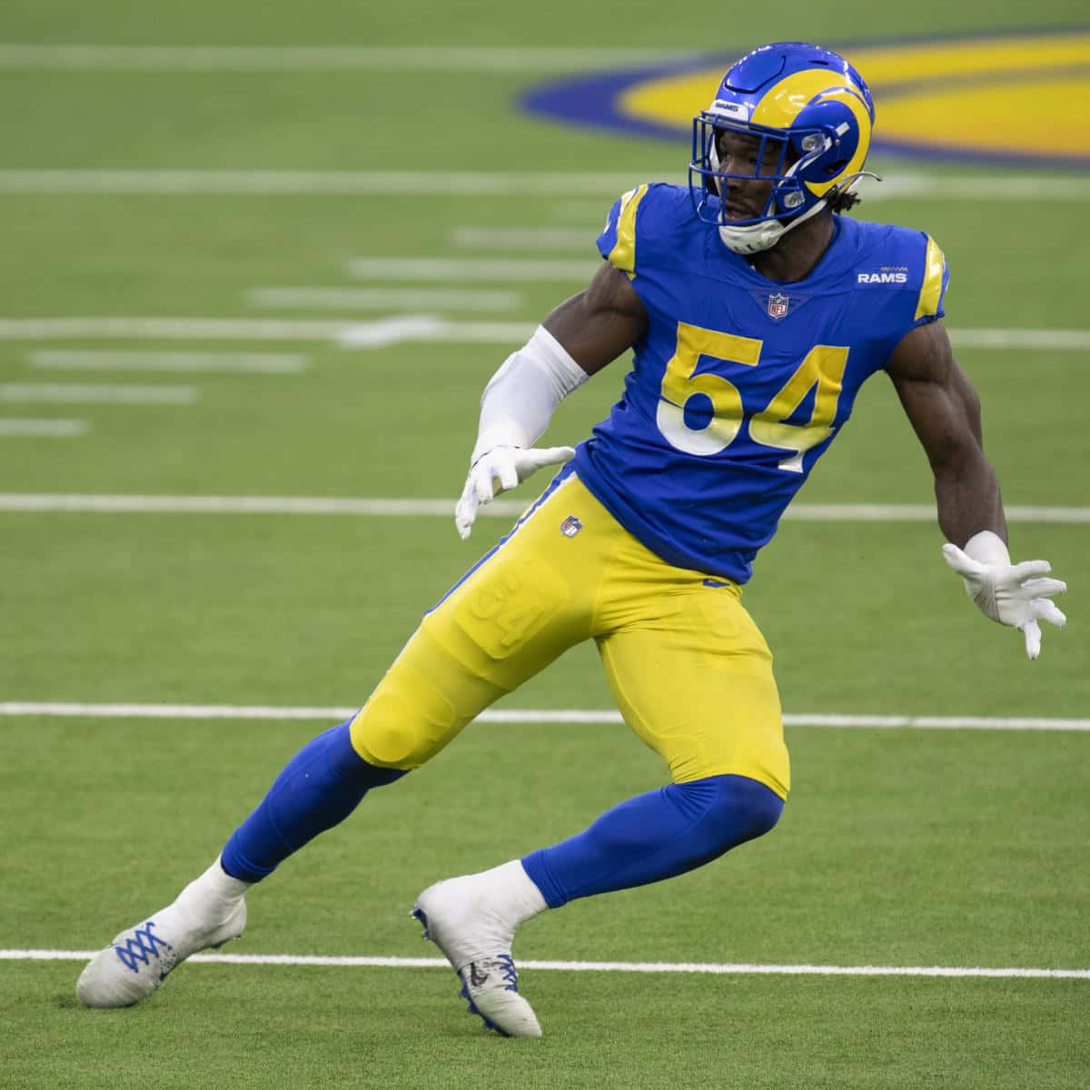 Football Players 桌布 壁紙 — 一名身穿藍色和金色球衣的洛杉磯公羊隊美式足球員在比賽期間於綠色球場上衝刺。