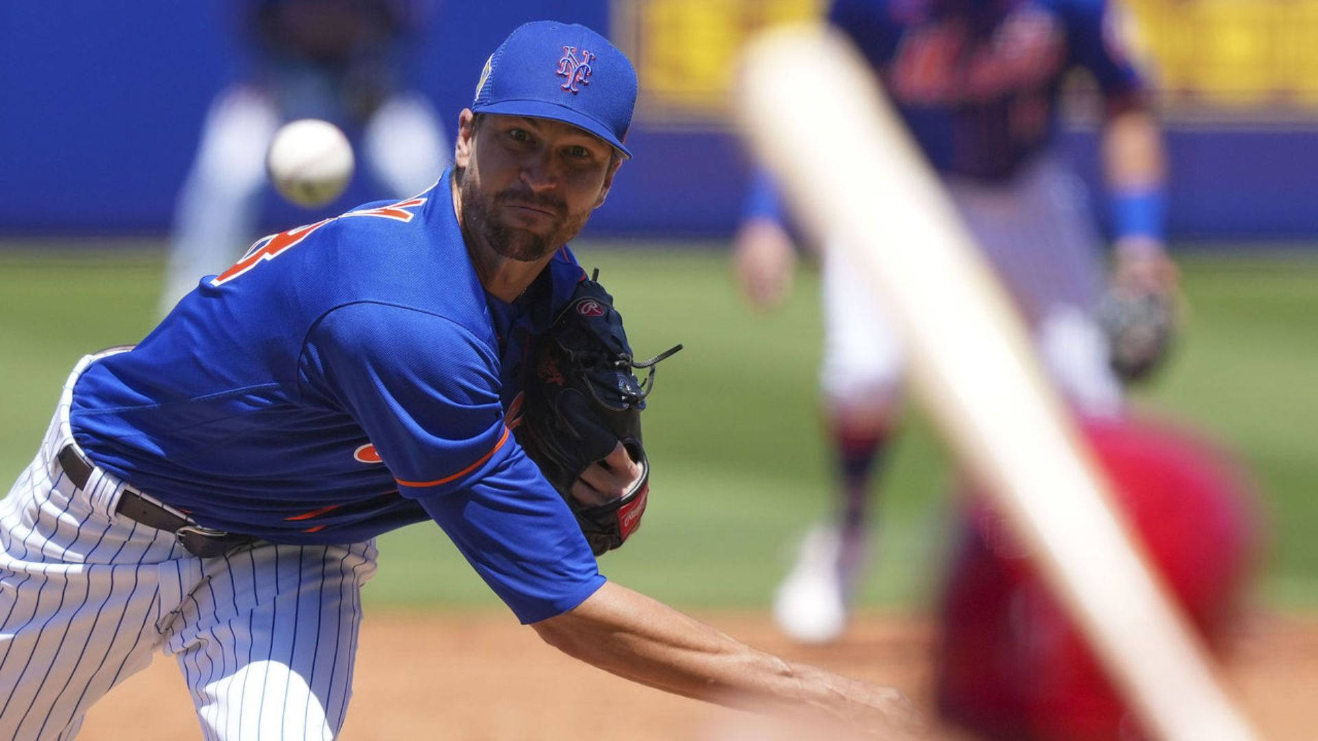 Degrom 桌布 壁紙 — 一名身穿藍色大都會隊球衣的棒球投手，在強烈專注下投球，背景中一名打者正在揮棒。