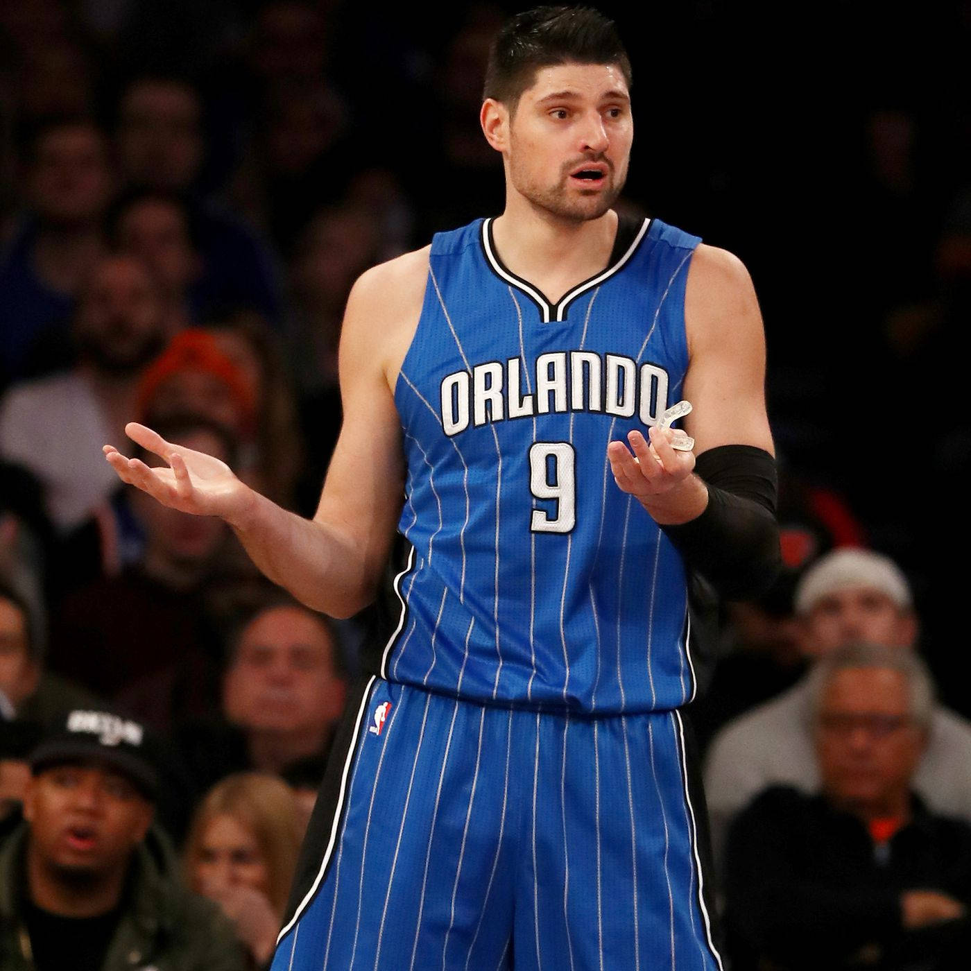 NBA 桌布 壁紙 — 一名身穿藍色奧蘭多球衣、背號9號的籃球運動員，在明亮的場館燈光下比賽中沮喪地做手勢。