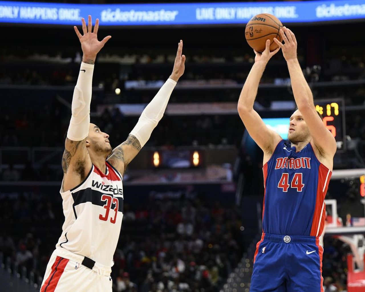 NBA 桌布 壁紙 — 一名身穿藍色底特律球衣的籃球運動員投籃，而華盛頓巫師隊的防守球員跳起封阻。