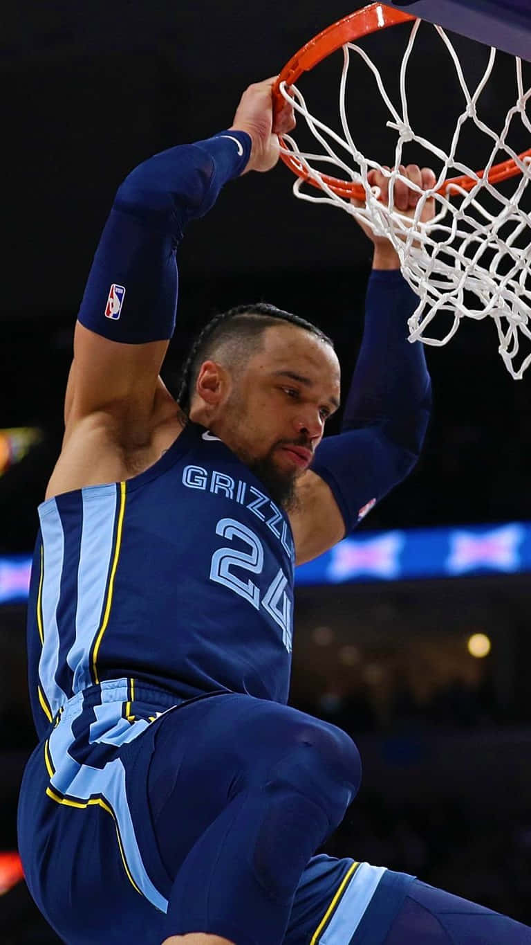 Dillon Brooks 桌布 壁紙 — 一名身穿藍色灰熊隊球衣的籃球運動員，在模糊的球場背景下，專注地灌籃。