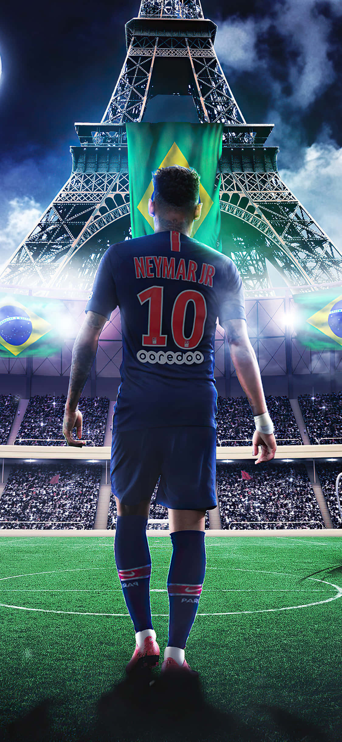 Neymar iPhone 桌布 壁紙 — 一名身穿藍色球衣、背號10號的足球員站在球場上，面向披著巴西國旗的艾菲爾鐵塔，在戲劇性的球場燈光下。