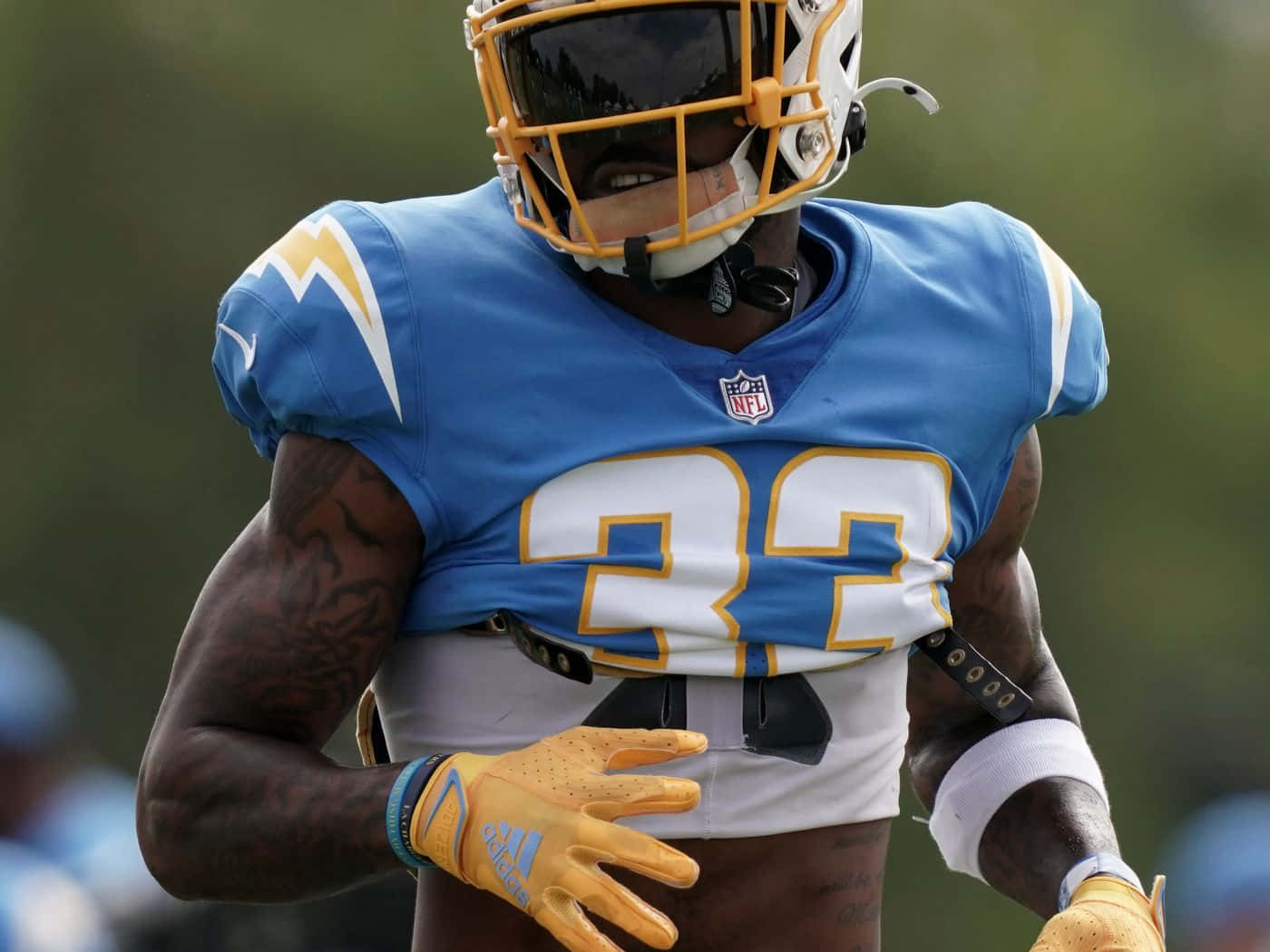 NFL 桌布 壁紙 — 一名身穿藍色球衣、號碼32的美式足球員在球場上奔跑的特寫。