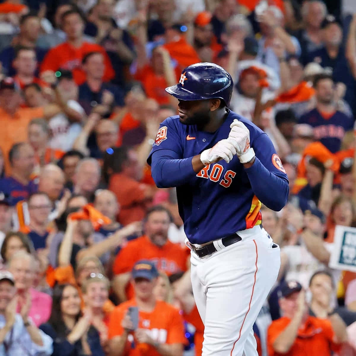 Astros 桌布 壁紙 — 一名身穿藍色球衣的休士頓太空人棒球選手交叉雙臂慶祝，身後身穿橙色衣服的球迷正在歡呼。