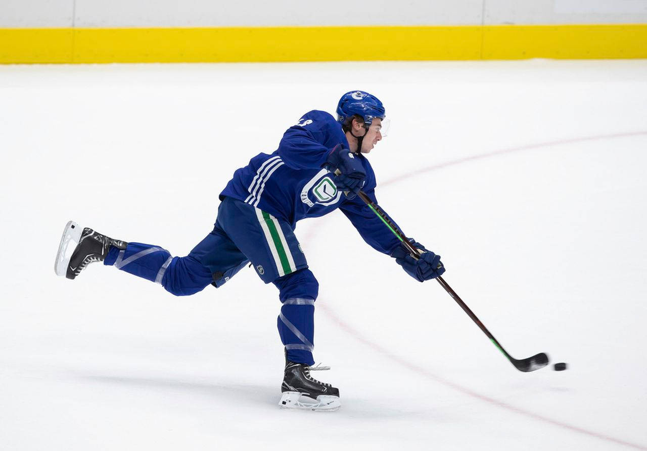 hockey 桌布 壁紙 — 一名身穿藍色球衣的冰球運動員在訓練期間在冰場上彎腰向前滑行，手持球桿。