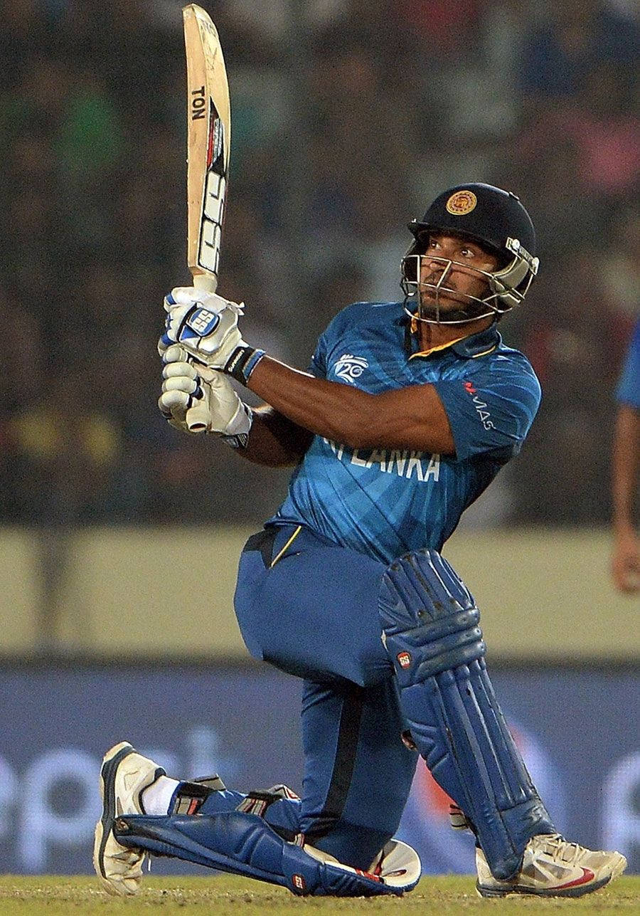Sri Lanka Cricket 桌布 壁紙 — 一名身穿藍色球衣的斯里蘭卡板球擊球手在夜間比賽中，在球場燈光下強力揮動球棒。