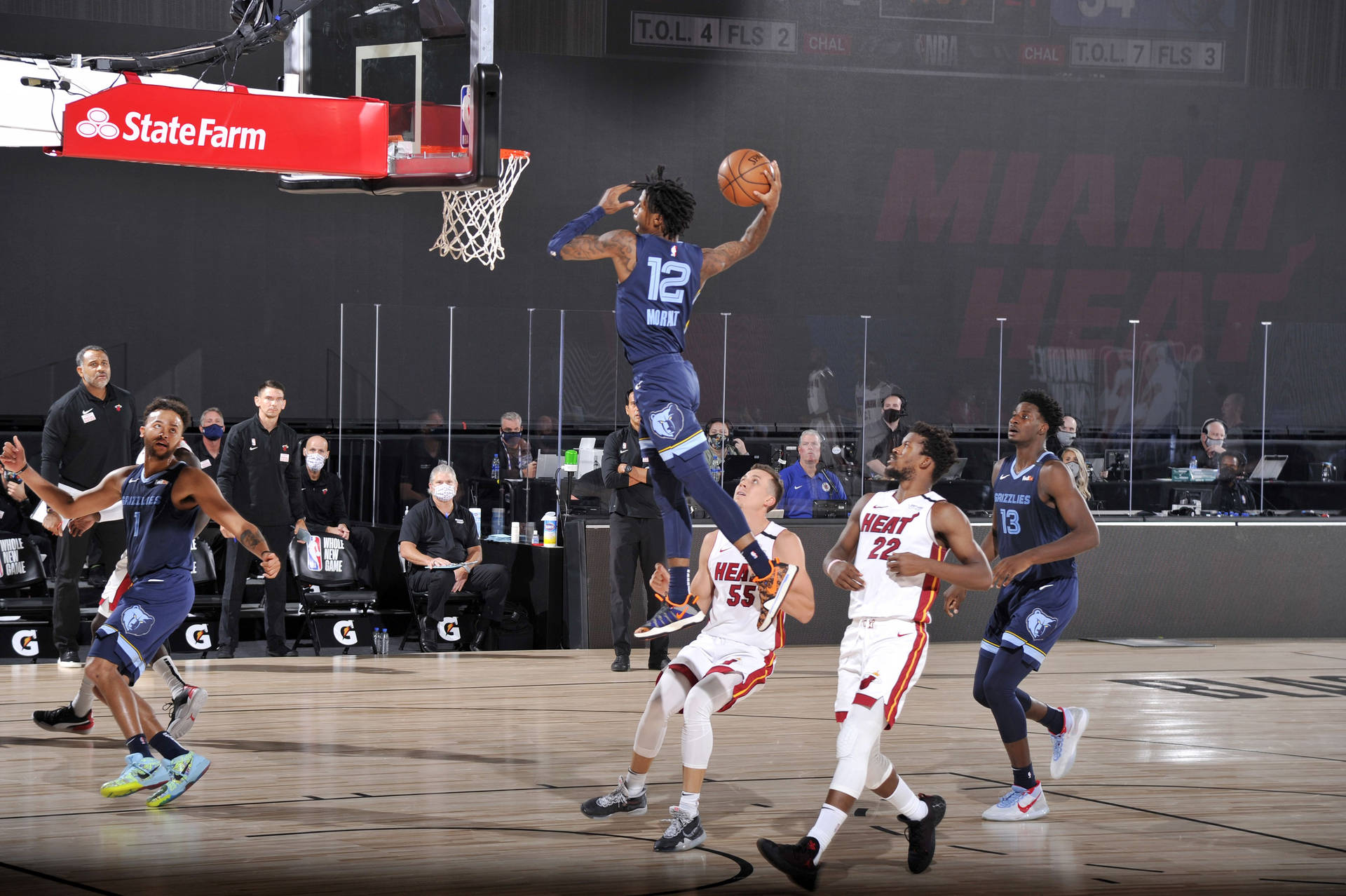 籃球運動員在半空中越過防守球員灌籃。 — Ja Morant 動圖 壁紙
