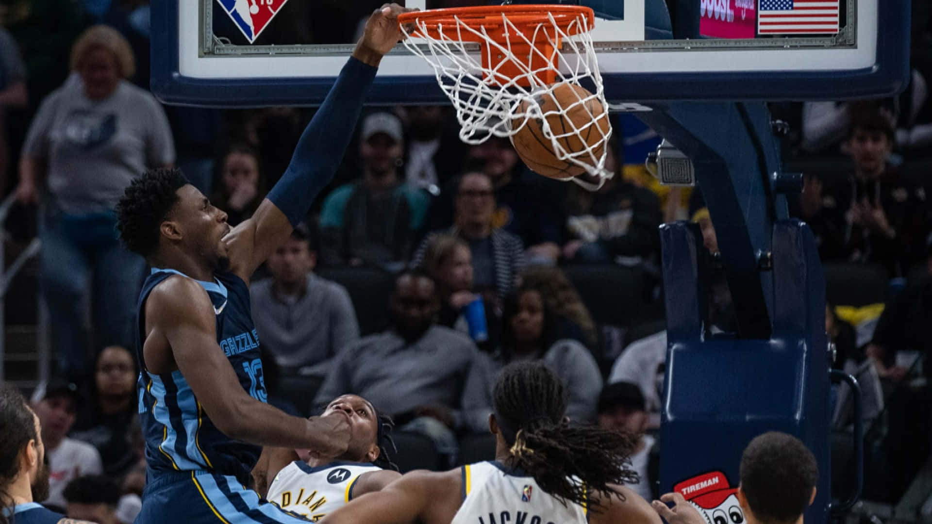 NBA Teams 桌布 壁紙 — 一名身穿藍色球衣的籃球運動員在明亮的場館燈光下灌籃，而一名身穿白色球衣的防守球員試圖封阻。