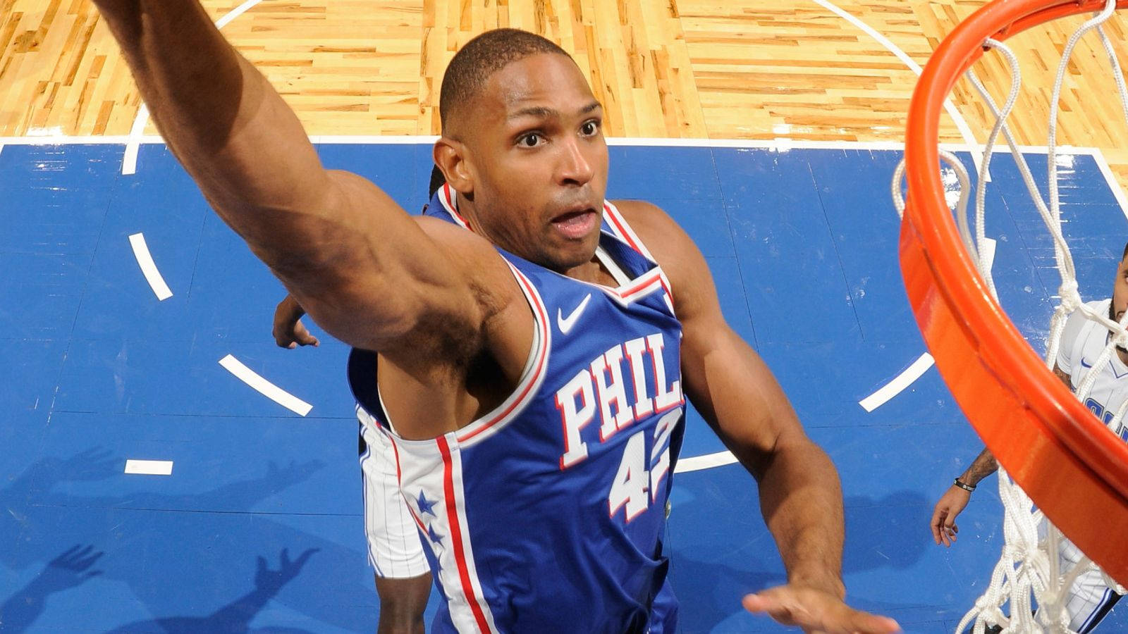 Al Horford 桌布 壁紙 — 一名身穿藍色球衣的籃球運動員在木地板上，在籃框附近以高度專注力灌籃。