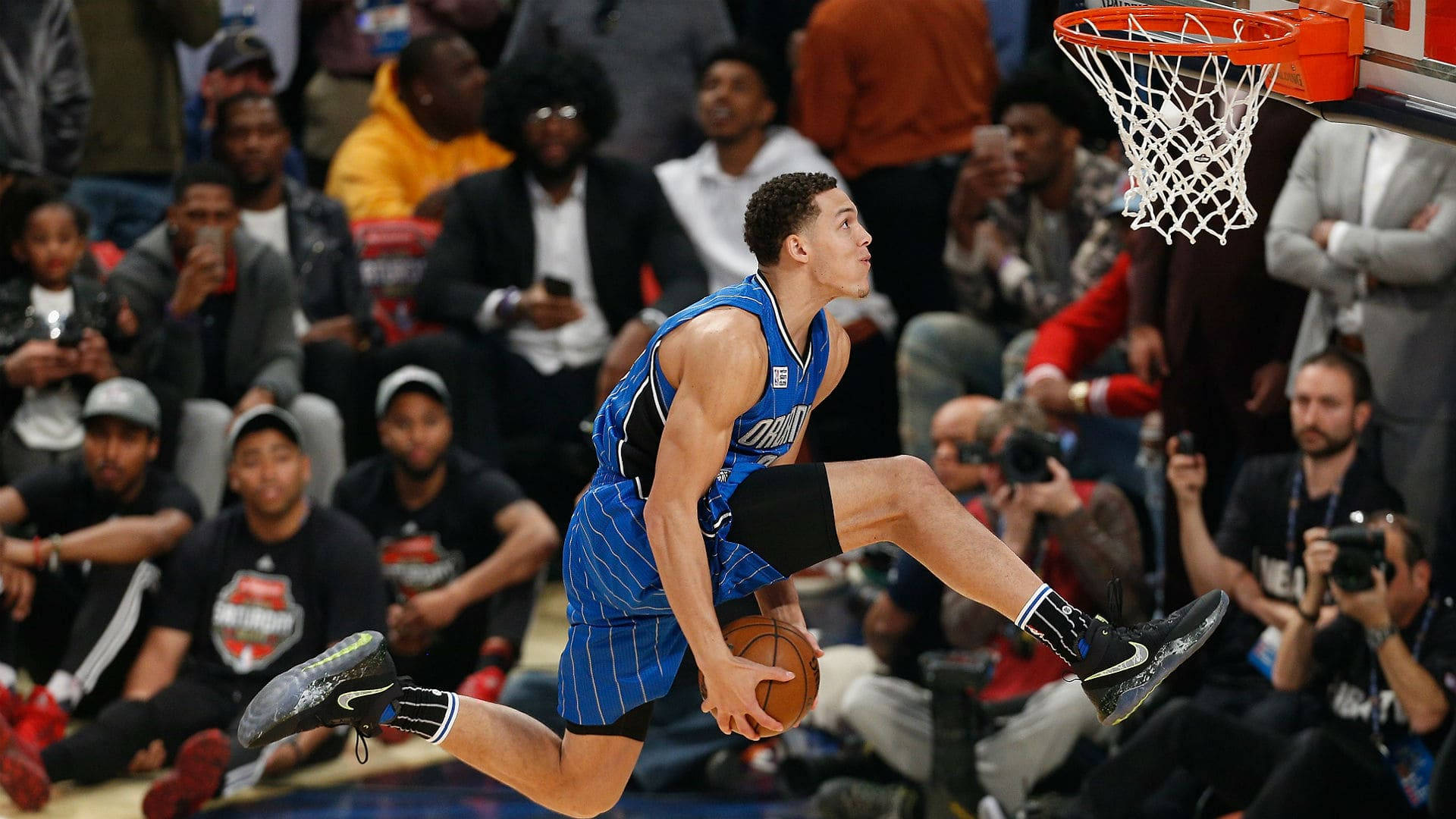 aaron gordon 桌布 壁紙 — 一名身穿藍色球衣的籃球運動員躍起灌籃，觀眾專注觀看。