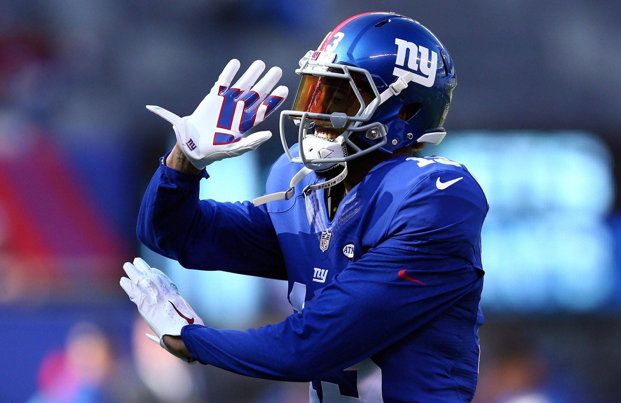 Odell 桌布 壁紙 — 一名身穿藍色球衣的紐約巨人隊美式足球員在球場燈光下帶著喜悅的表情向球迷揮手。