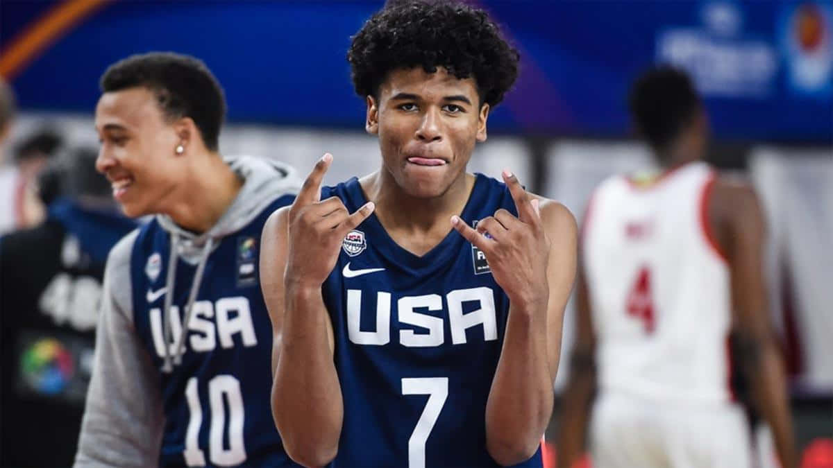 美國籃球運動員做出手勢，背景中的隊友在微笑。 — NBA 壁紙