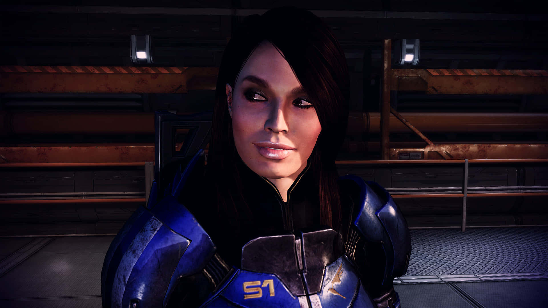 Ashley Williams 桌布 壁紙 — 一名身穿藍色盔甲、帶有「S1」徽章的女性士兵站在光線昏暗的工業走廊中，周圍有金屬管道和發光的燈光。