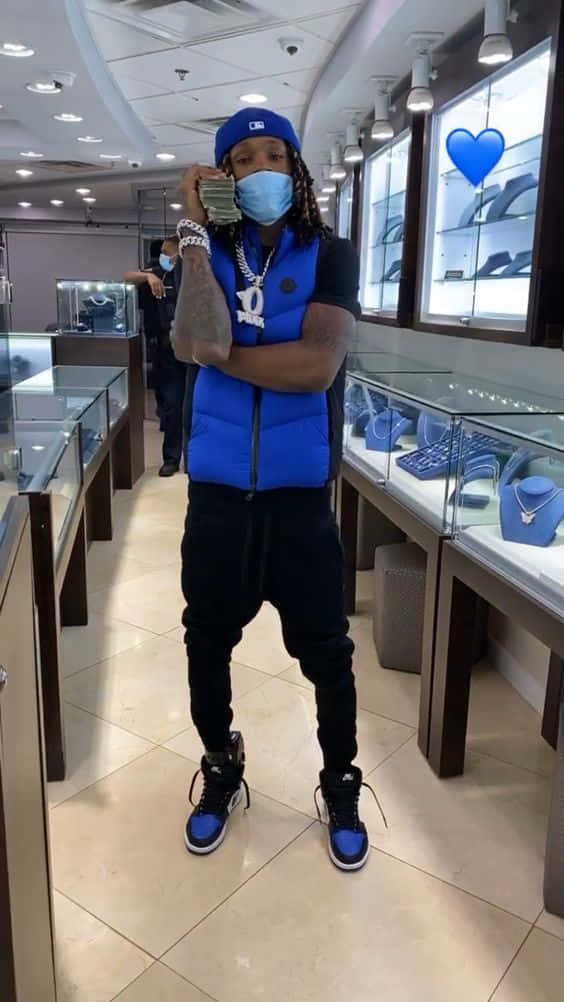 男子在珠寶店手持現金，身穿藍色背心和口罩。 — King Von 壁紙