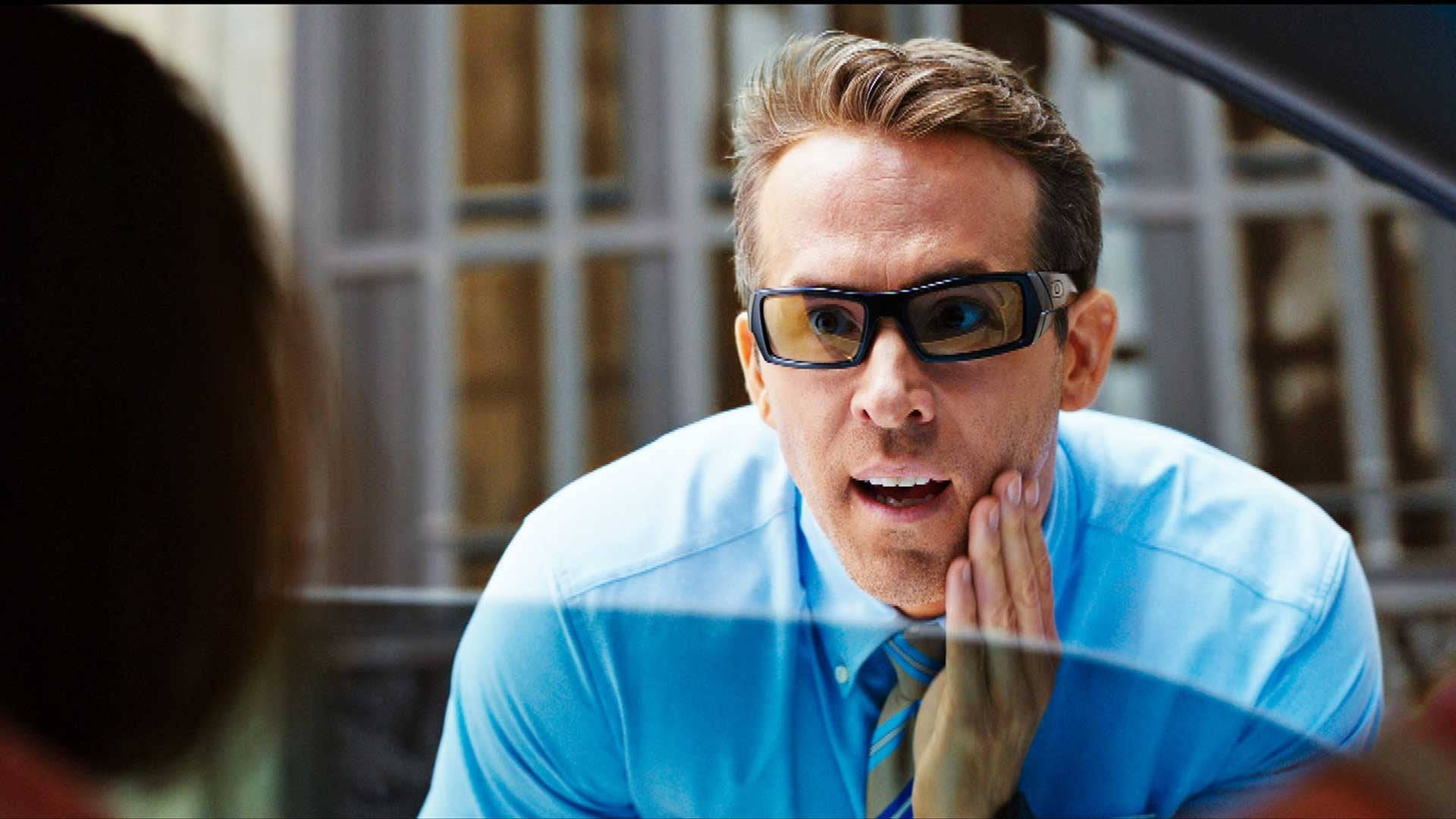 Sunglasses 桌布 壁紙 — 一名身穿藍色襯衫、戴著3D眼鏡的男子，手托臉頰，身體前傾，表情震驚。