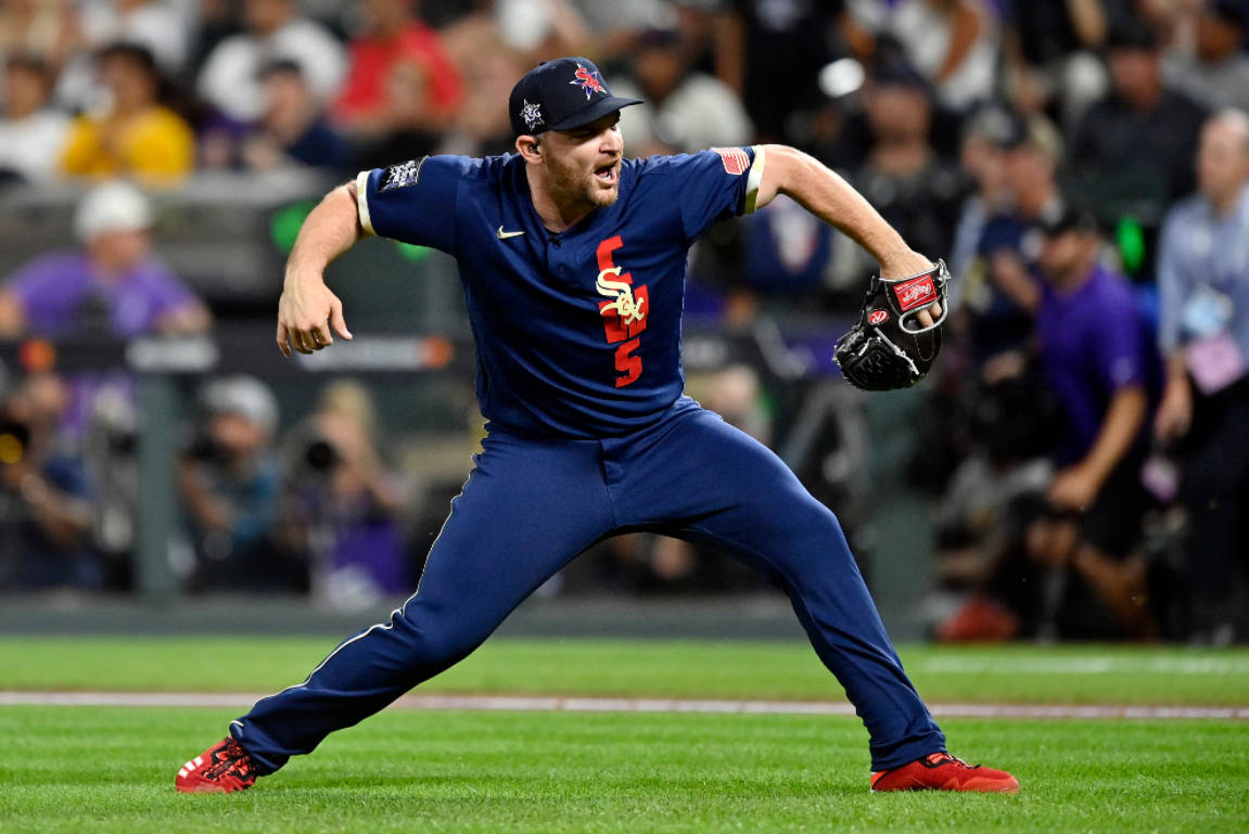 Chicago White Sox 桌布 壁紙 — 一名身穿藍色配紅色點綴球衣的棒球選手，在球場燈光下的綠色場地上投球。
