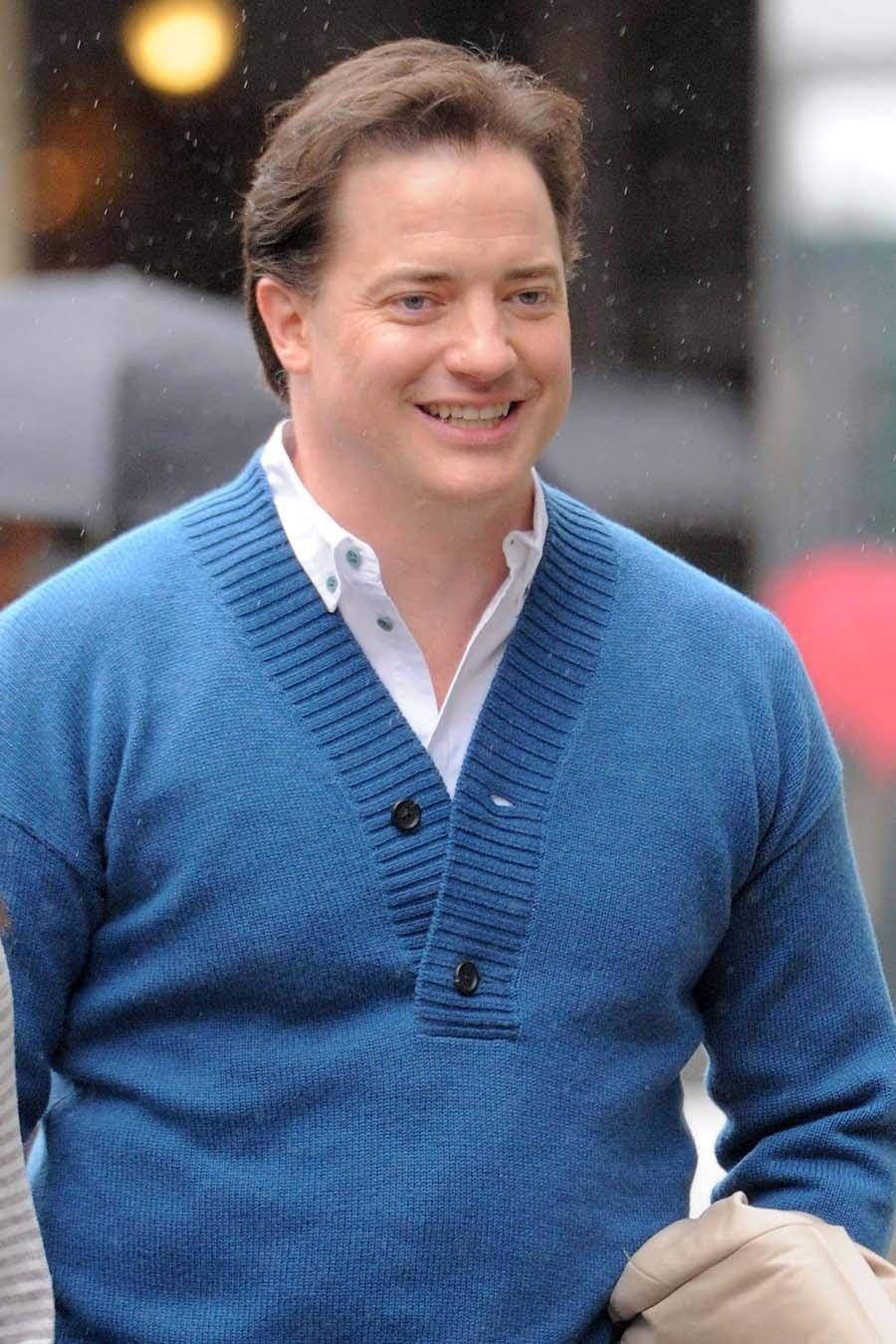 Celebrity 桌布 壁紙 — 一名身穿藍色針織開襟衫的男子在戶外微雨中行走，露出溫暖的笑容。