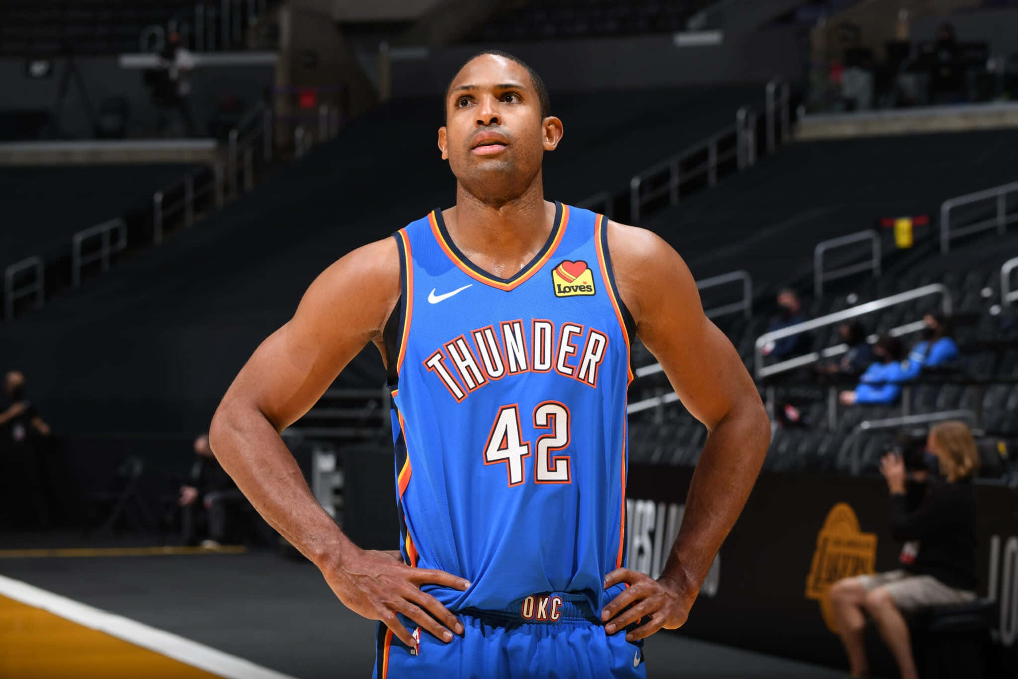 Al Horford 桌布 壁紙 — 一名身穿藍色雷霆隊球衣、背號42的籃球運動員，雙手叉腰自信地站在球場上。