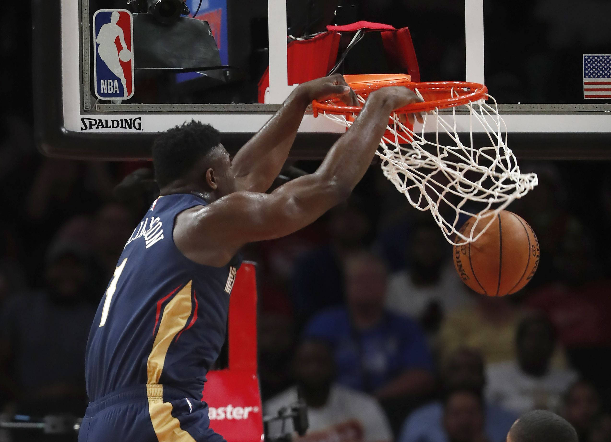 Zion 桌布 壁紙 — 一名身穿藍金色球衣的籃球運動員在NBA比賽中，於場館燈光下強力灌籃。