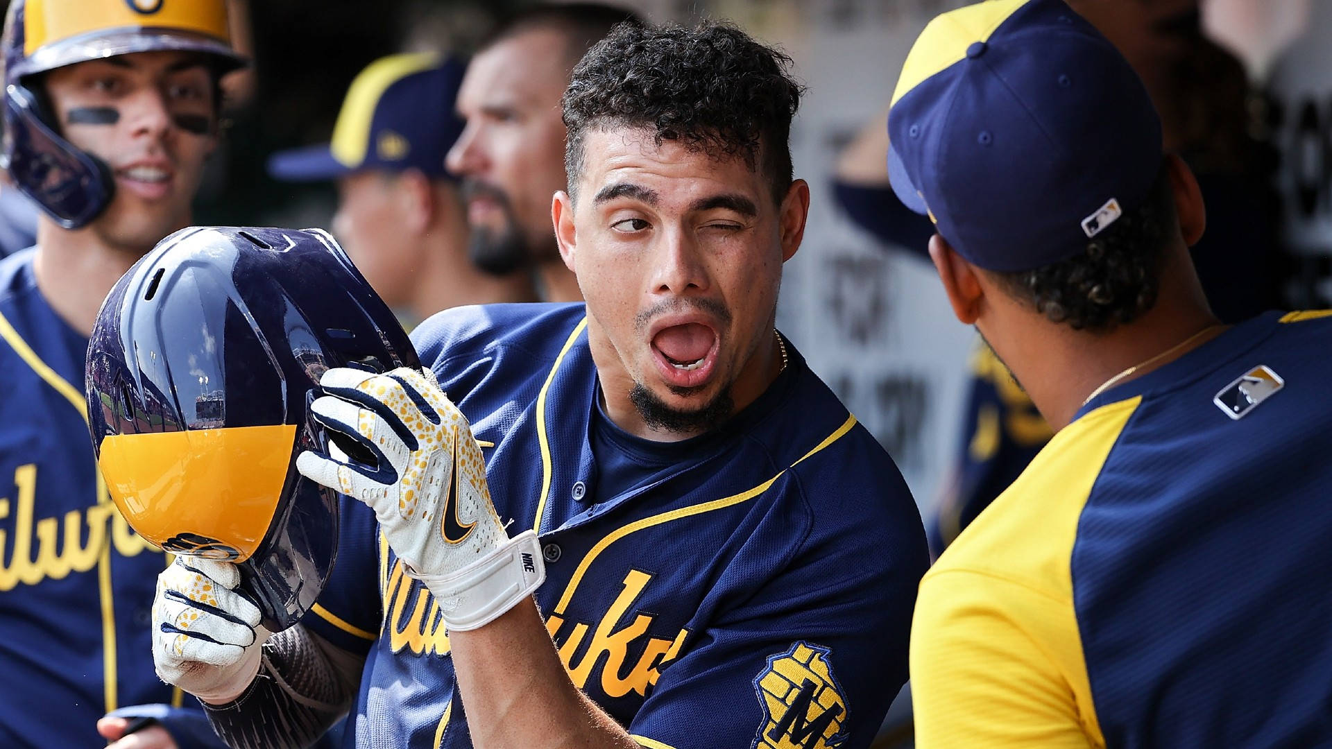 Brewers 桌布 壁紙 — 一名身穿藍黃色球衣的棒球運動員在休息區戴著頭盔，睜大眼睛張開嘴巴做出反應。